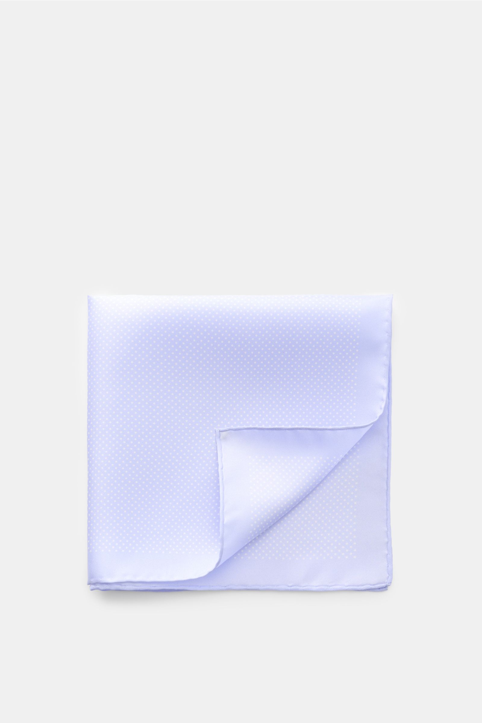 Top-down view of Tom Ford Seiden-Einstecktuch hellblau/weiß gepunktet, a light blue silk pocket square with white dots, rolled edges, smooth texture, small TOM FORD print, made in Italy, approx. 39x39 cm. Dieses Einstecktuch von TOM FORD aus reiner Sei