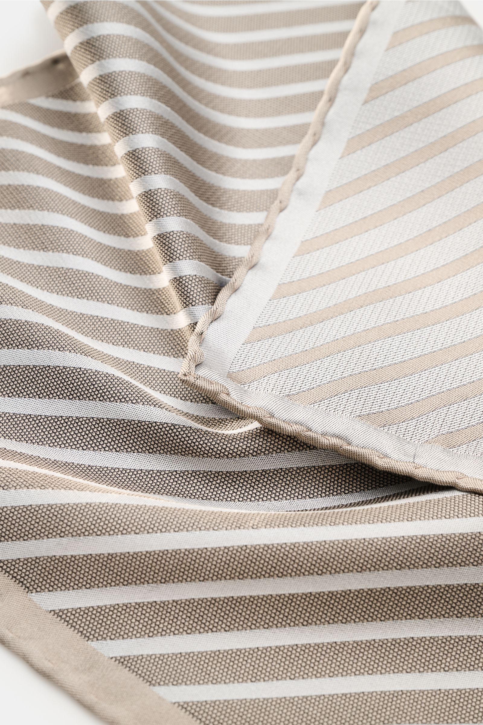 Close-up top-down view of the Brunello Cucinelli Seiden-Einstecktuch bordeaux gestreift showing fabric texture and hand-rolled edges. Features: 

reine Seide
geschmeidiger Griff
Streifenmuster
handrollierte Kanten
