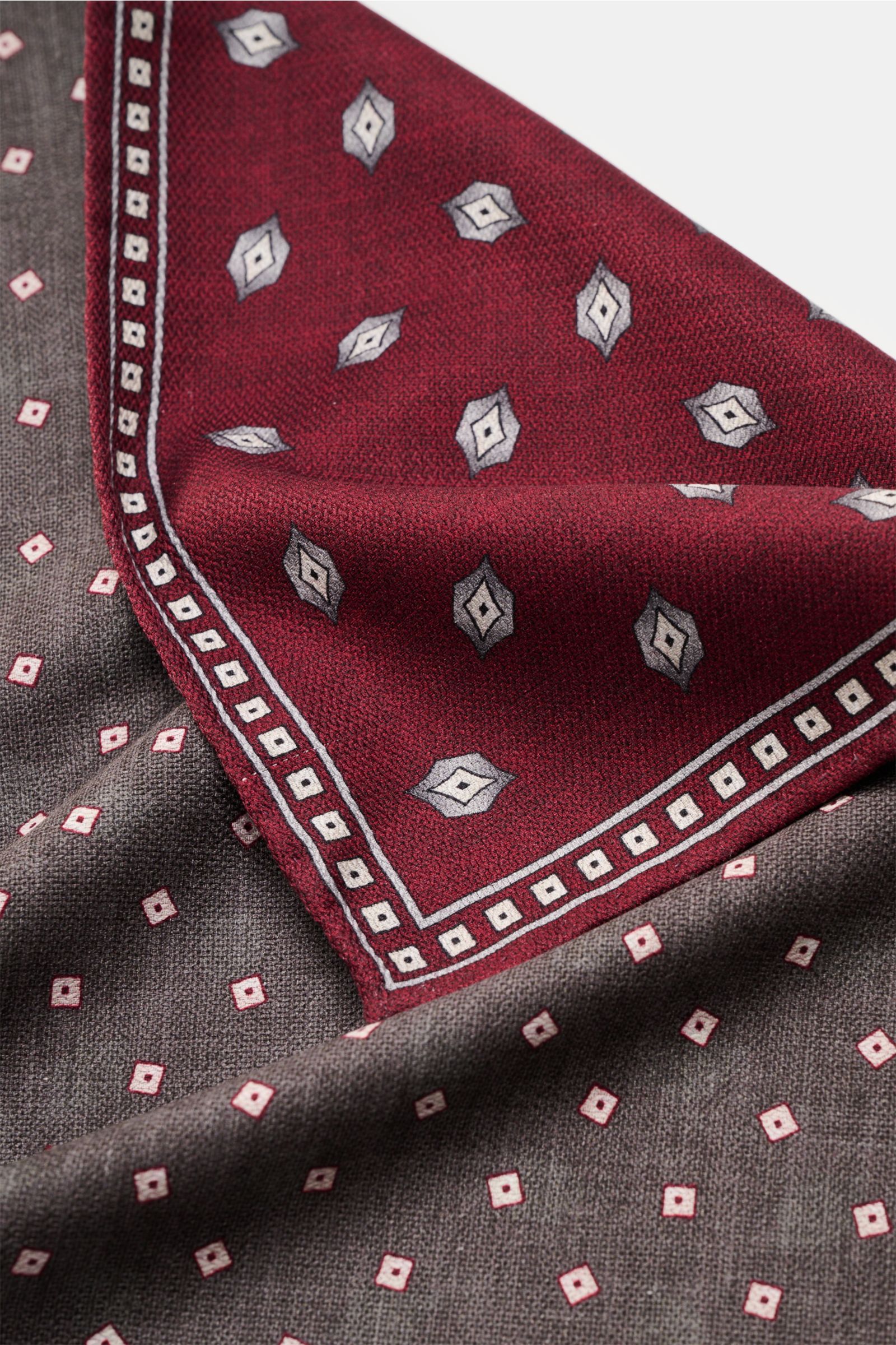 Brunello Cucinelli Seiden-Einstecktuch graugrün/grau gemustert shown close-up from above, displaying fabric texture, pattern, and handrolled edges;  

reine Seide
geschmeidiger Griff
handrollierte Kanten
Made in Italy