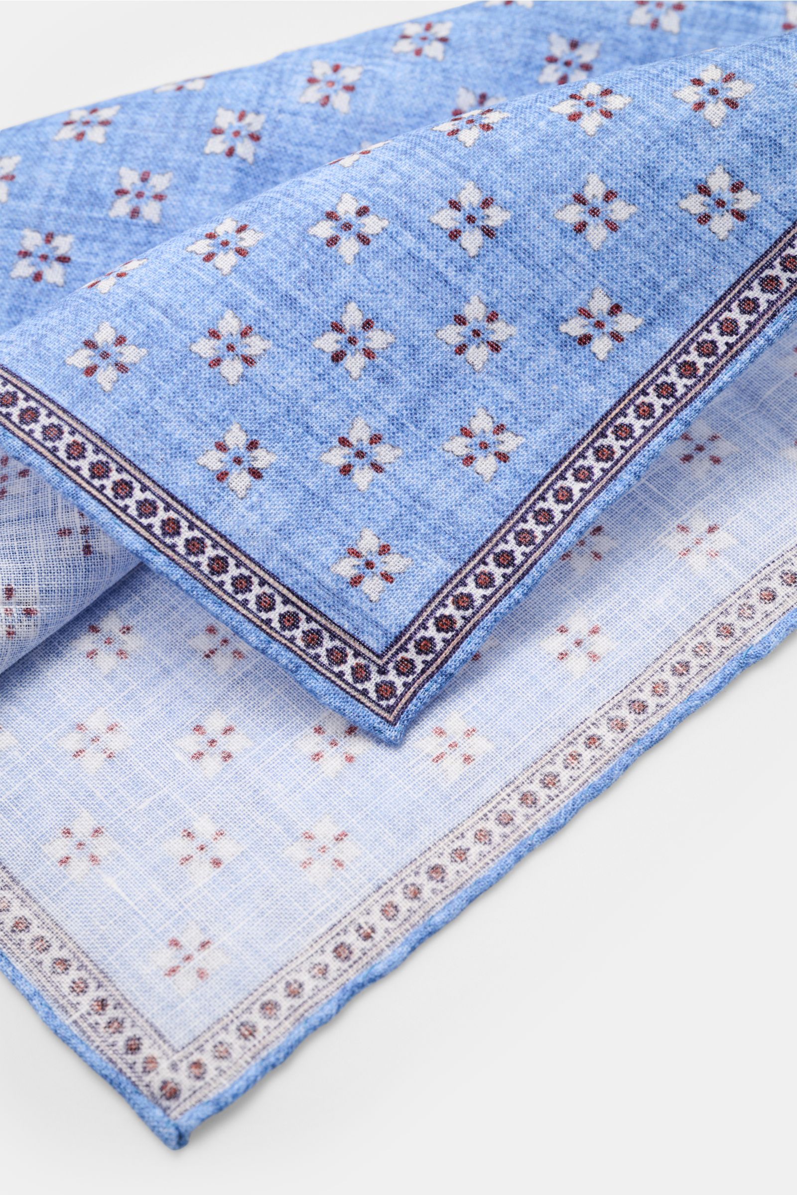 Rosi Collection Linen-pocket square 'Fox' blue/red-brown/off-white patterned, pure linen with soft feel, floral print with edging, rolled edges, made in Italy, 31x31 cm, photographed close-up from an angled top view.