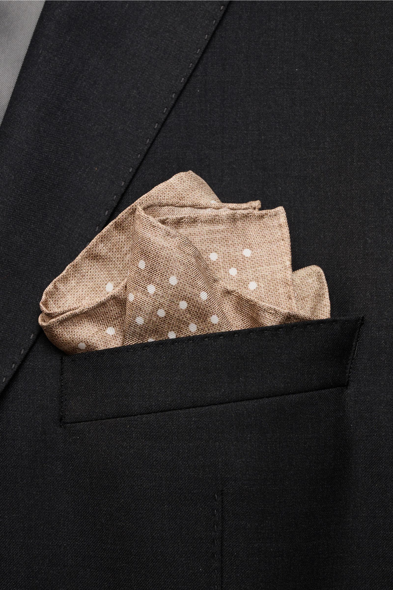 Rosi Collection Silk pocket square 'Silk' beige/white with polka dots in black jacket pocket, photographed from above; pure silk, soft smooth touch, rolled edges, made in Italy, approx. 31 cm x 31 cm.