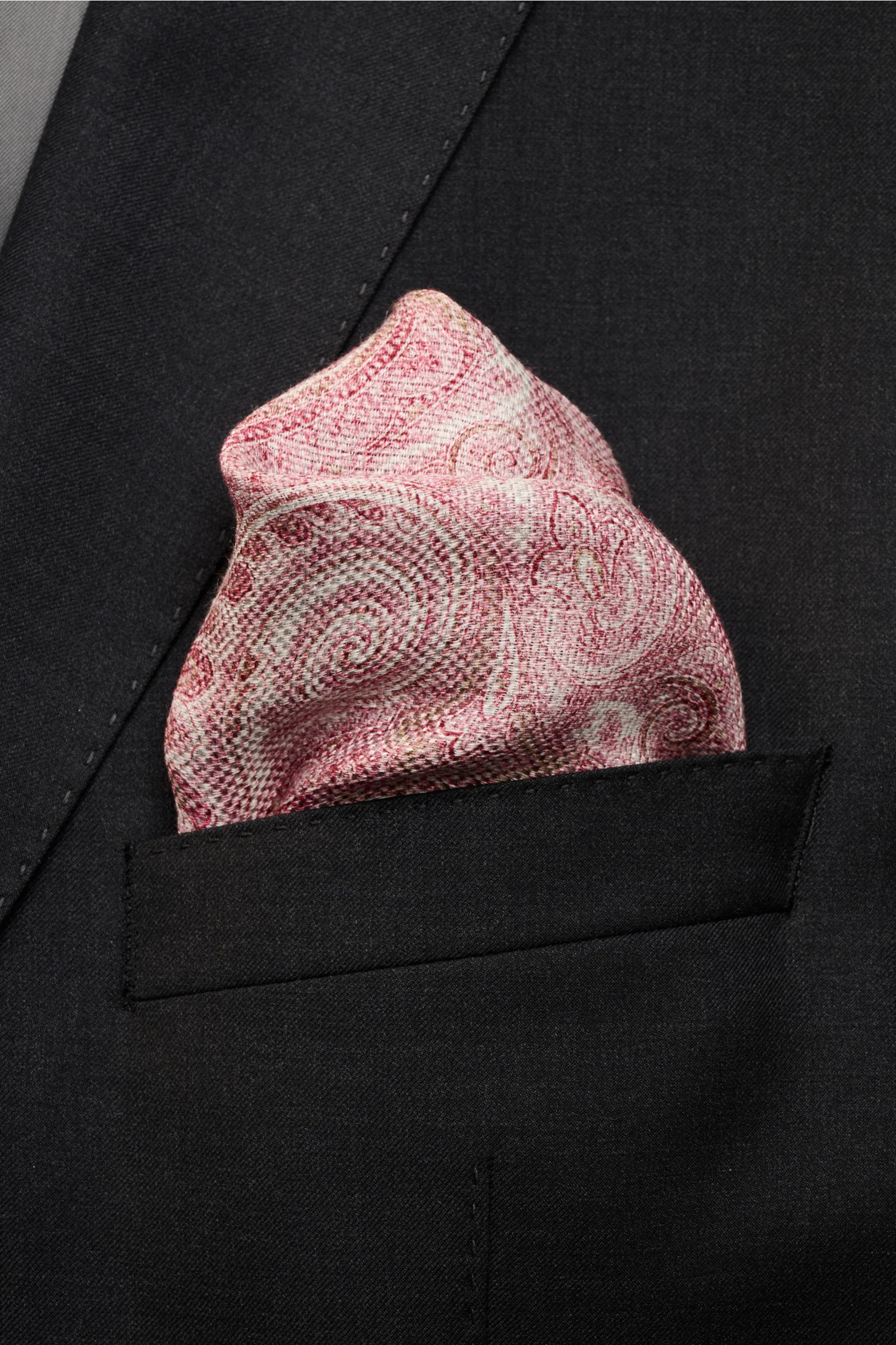 Rosi Collection Einstecktuch 'Joy' magenta/altrosa/weiß gemustert pocket square with paisley patterns, photographed close-up from the front in a black jacket pocket. Eleganter Eyecatcher: Mit seinem modernen Paisley-Muster wird das Einstecktuch von ROS