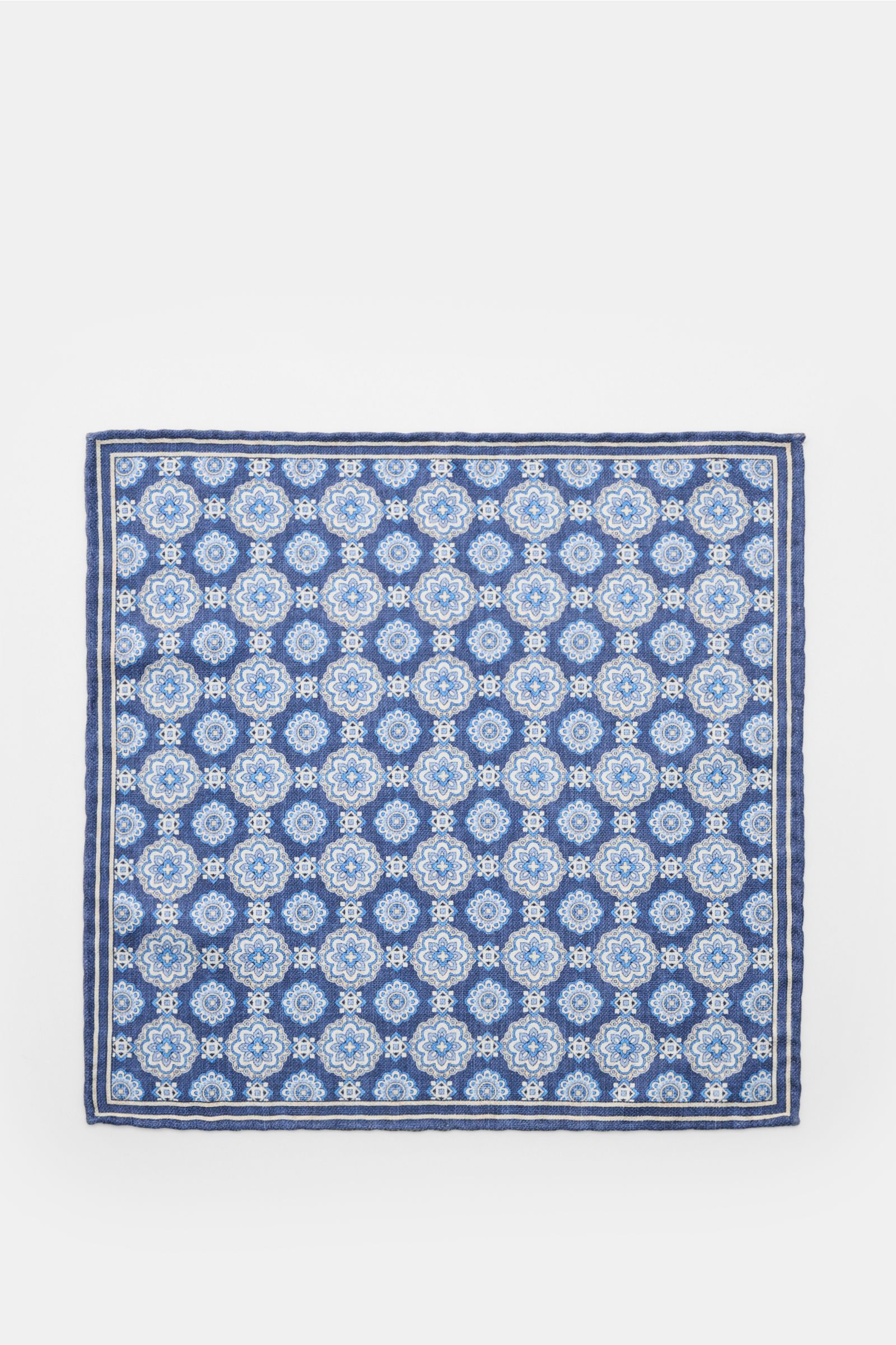 Top-down view of the Rosi Collection Seiden-Einstecktuch 'Easy' dunkelblau/blau/creme gemustert pocket square, made of pure silk with a soft, smooth feel, featuring an elegant medallion print with border, contrasting reverse side, rolled edges, made in It