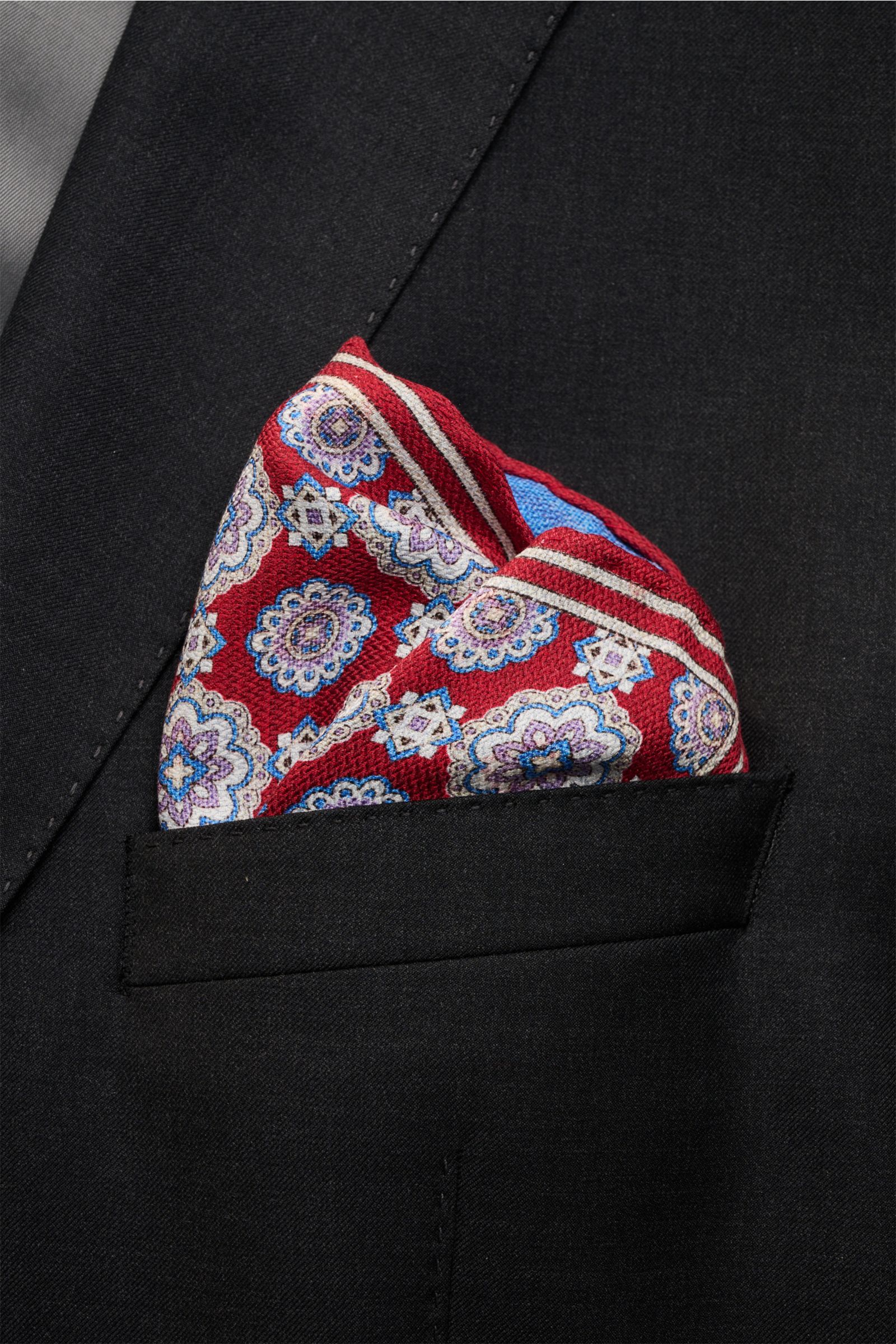 Rosi Collection Seiden-Einstecktuch 'Easy' rot/blau/flieder gemustert, reine Seide, Medaillon-Print, Borte, Kontrast, rollierte Kanten, Made in Italy, 31x31 cm, frontal in schwarzer Brusttasche.