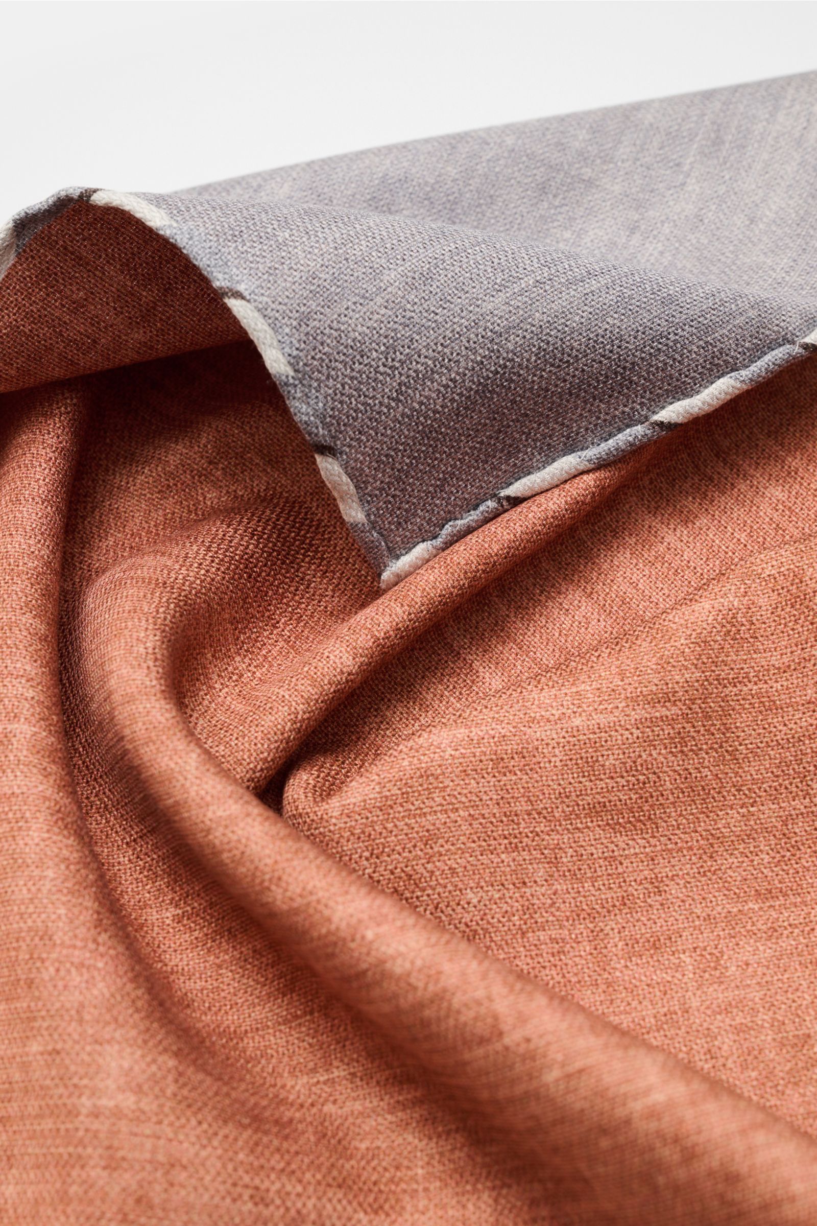 Brunello Cucinelli Seiden-Einstecktuch braun/grau meliert shown from a close-up angled perspective, highlighting texture and hand-rolled edges. Quiet Luxury kann BRUNELLO CUCINELLI besonders gut und bringt auch in dieser Saison passende Einstecktücher,