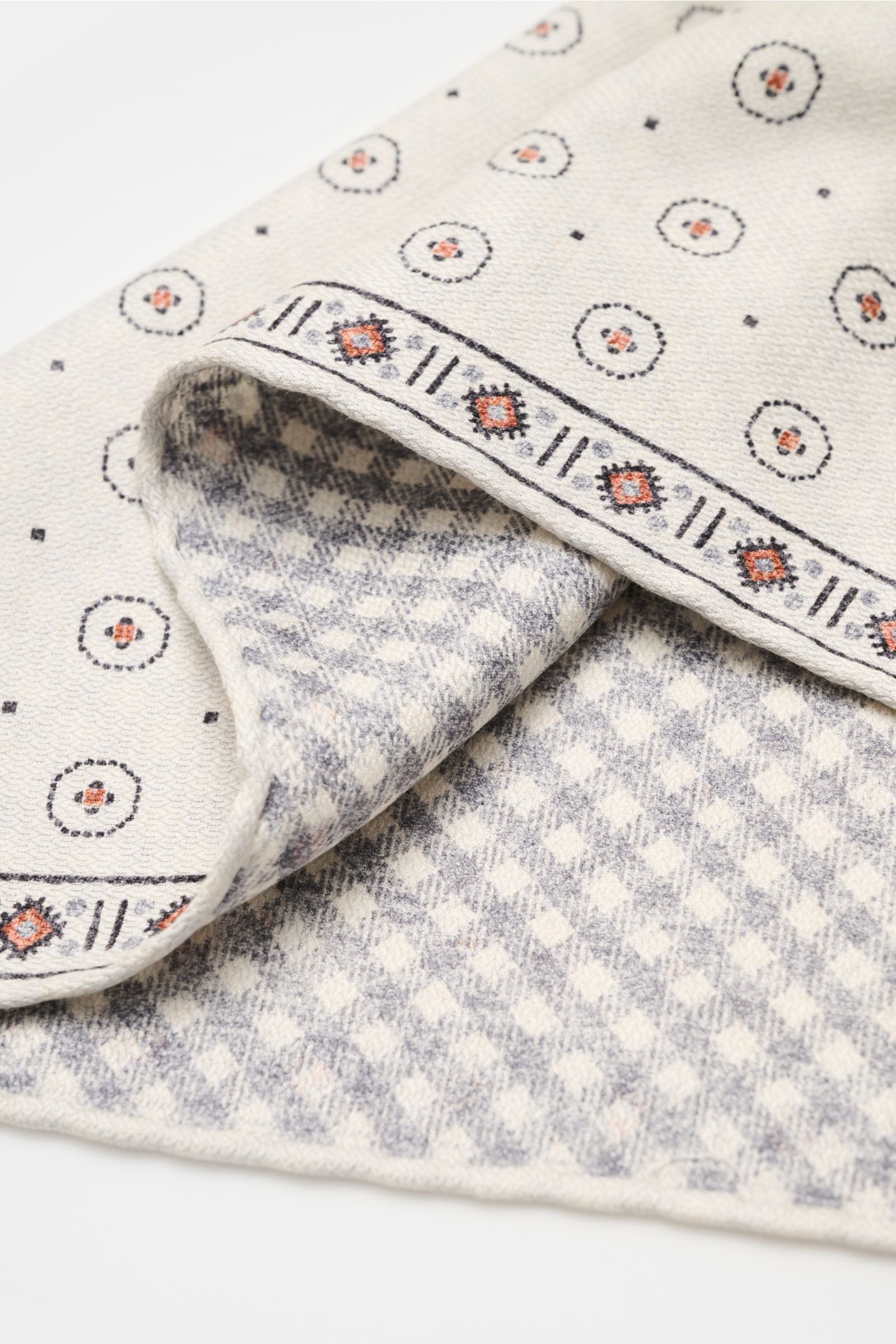 Brunello Cucinelli Seiden-Einstecktuch offwhite/apricot/navy gemustert shown folded from a close-up angle, featuring graphic print, silk, and contrasting patterns.

Zeitloser Akzent für besondere Momente: Das Einstecktuch aus reiner Seide von BRUNELLO 