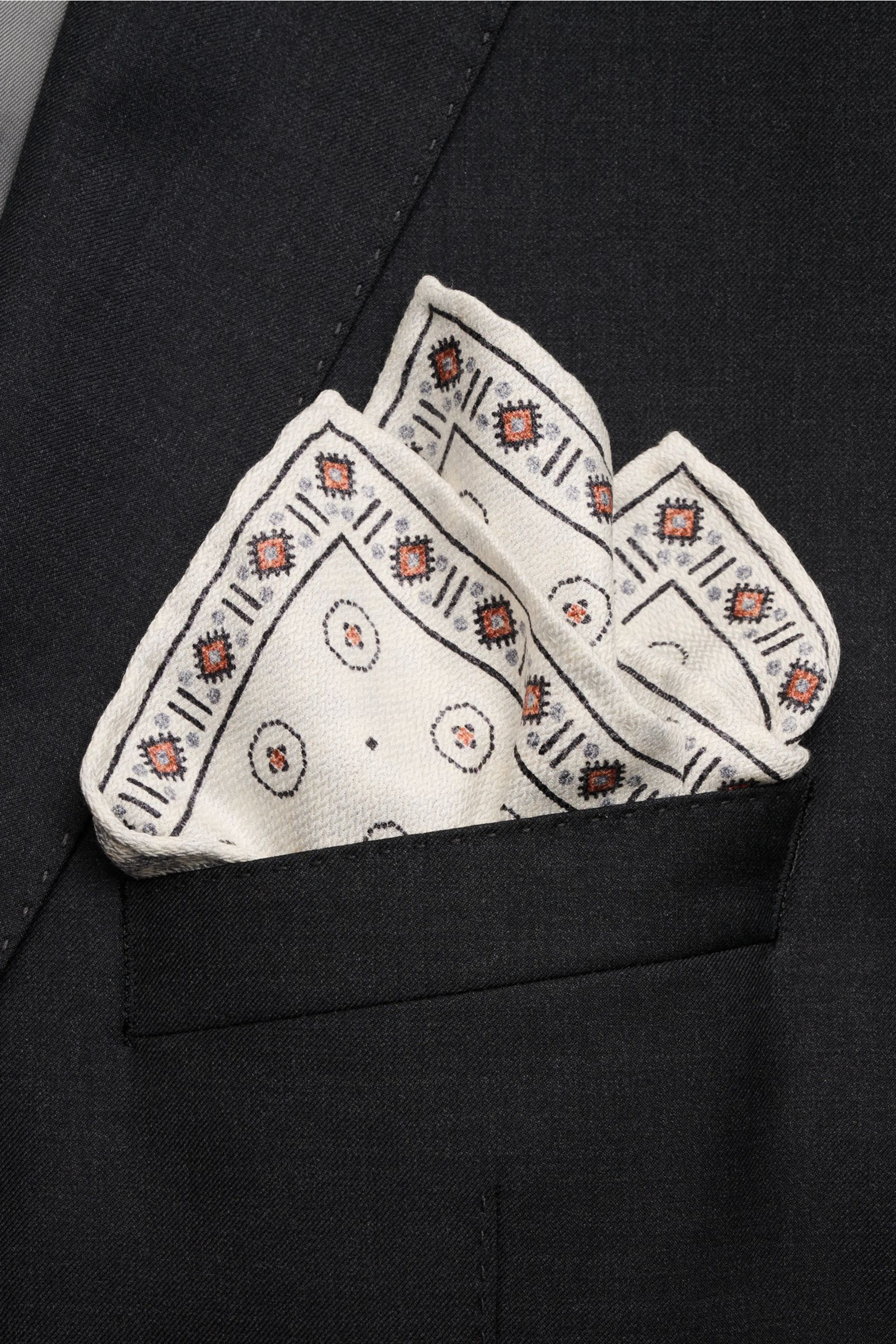 Close-up front view of Brunello Cucinelli Seiden-Einstecktuch offwhite/apricot/navy gemustert silk pocket square folded in a black jacket pocket.

Zeitloser Akzent für besondere Momente: Das Einstecktuch aus reiner Seide von BRUNELLO CUCINELLI verleiht