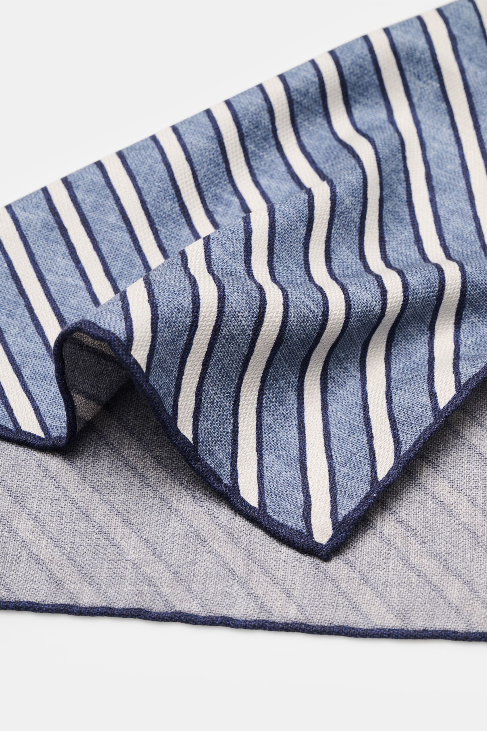 Brunello Cucinelli Seiden-Einstecktuch graublau/hellgrau/navy gestreift, reine Seide, handrollierte Kanten, seitliche Nahaufnahme, Quiet Luxury Trend.