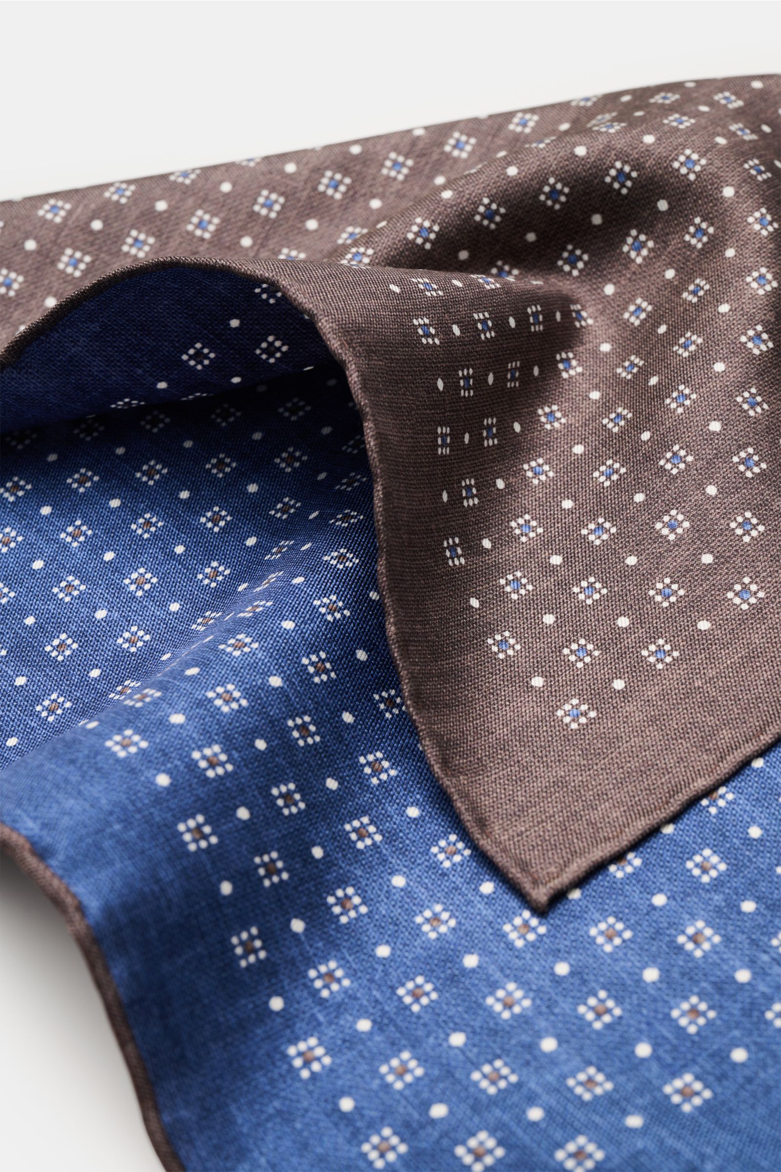 Close-up front view of the Brunello Cucinelli Seiden-Einstecktuch dunkelblau/graubraun/weiß gemustert with a graphic pattern in blue, gray-brown, and white.

Quiet Luxury kann BRUNELLO CUCINELLI besonders gut und bringt auch in dieser Saison passende E