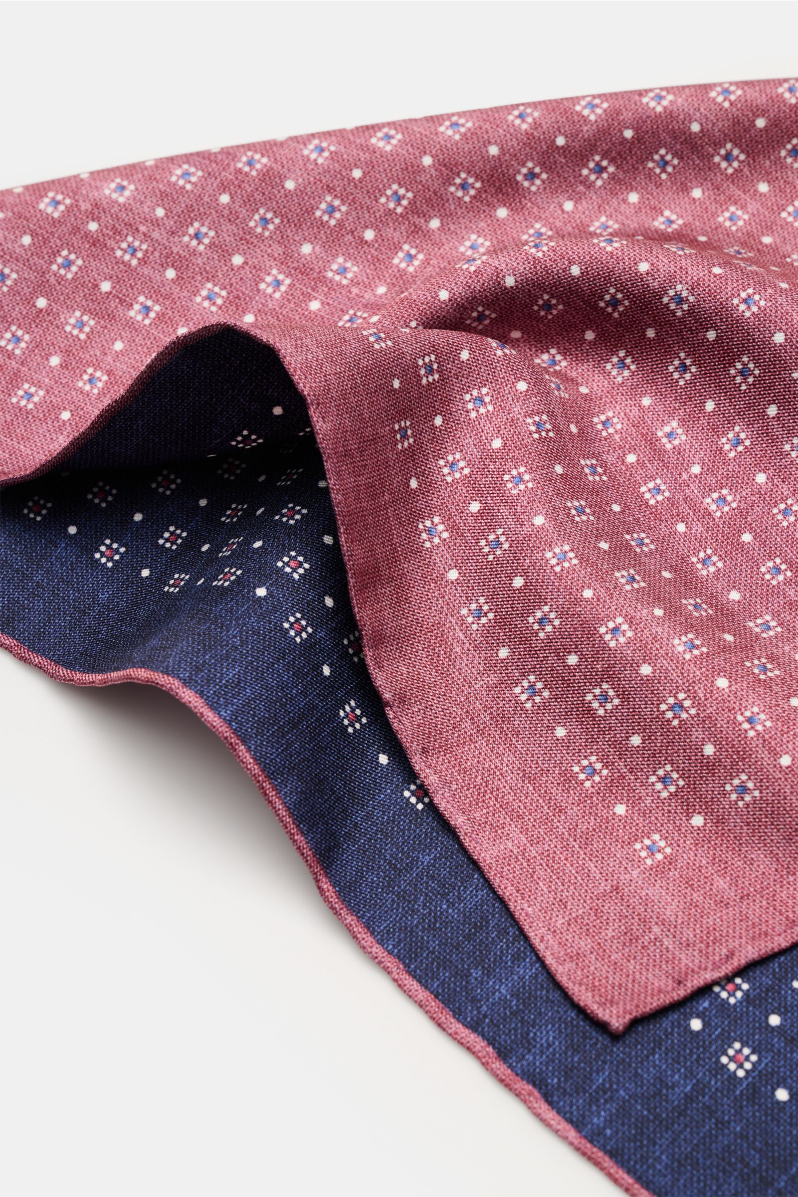 Close-up, angled view of Brunello Cucinelli Seiden-Einstecktuch bordeaux/navy/weiß gemustert with a graphic pattern, soft silk texture, hand-rolled edges.

Quiet Luxury kann BRUNELLO CUCINELLI besonders gut und bringt auch in dieser Saison passende Ein