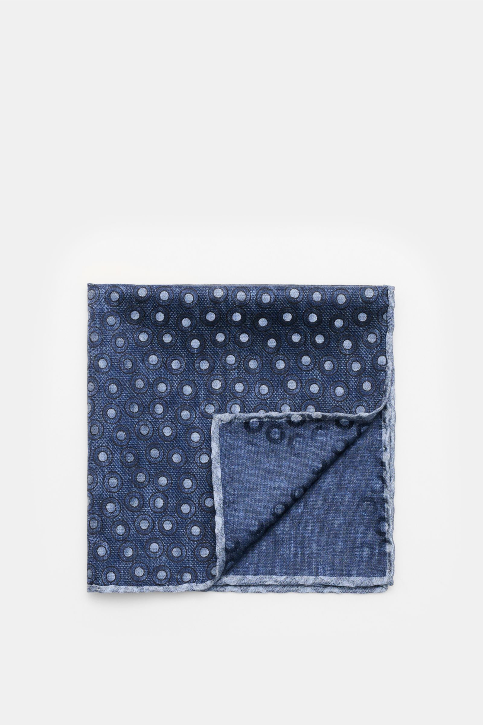Brunello Cucinelli Seiden-Einstecktuch navy/graublau gepunktet, folded with one corner flipped, showing silk fabric with smooth grip, dotted pattern, hand-rolled edges, made in Italy, approx. 35x35 cm, photographed from above. Quiet Luxury heißt der große