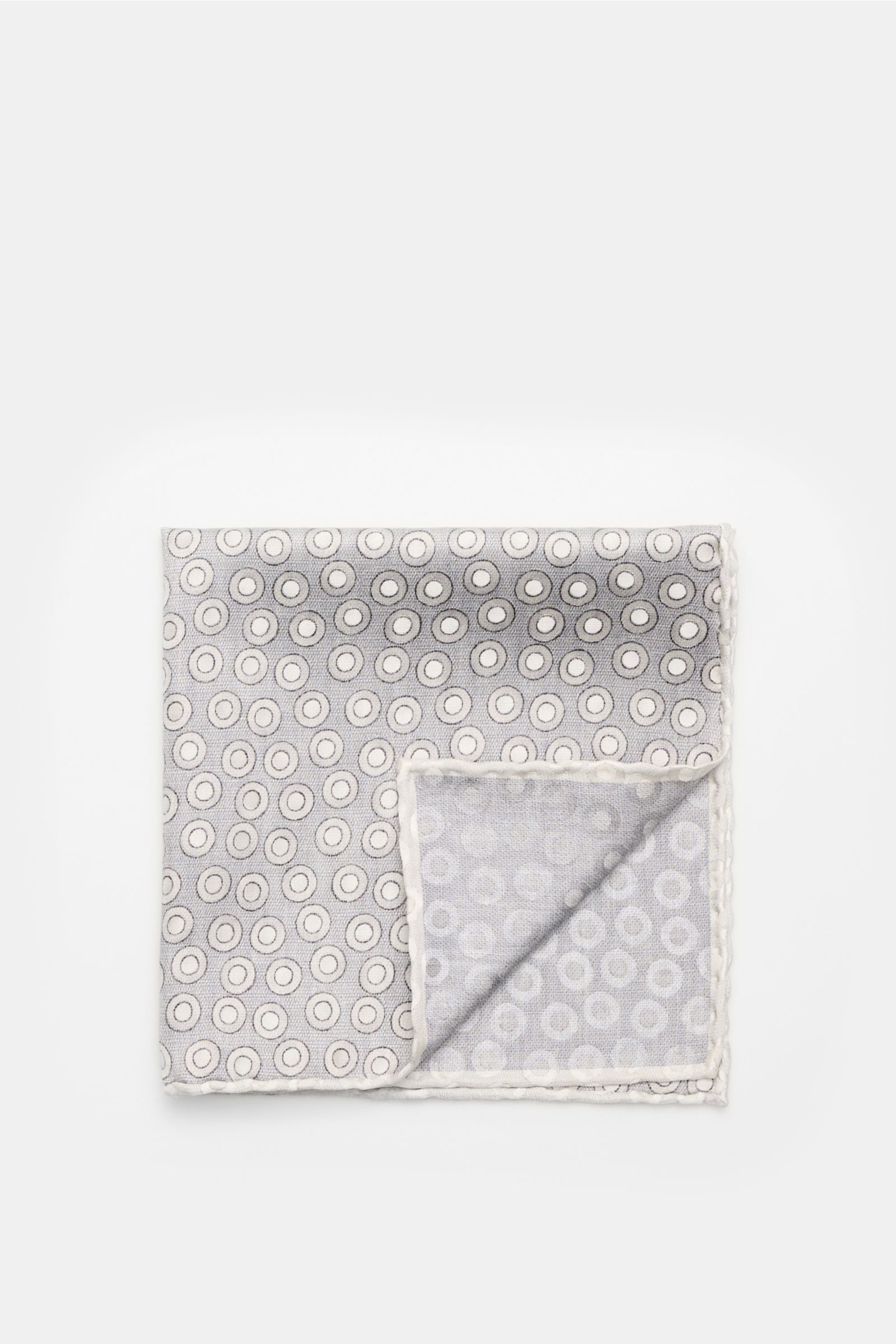 Brunello Cucinelli Seiden-Einstecktuch silbergrau/hellgrau gepunktet shown from top-down, folded to reveal handrollierte Kanten.  
Quiet Luxury heißt der große Trend: Das kann BRUNELLO CUCINELLI besonders gut und bringt auch in dieser Saison passende E
