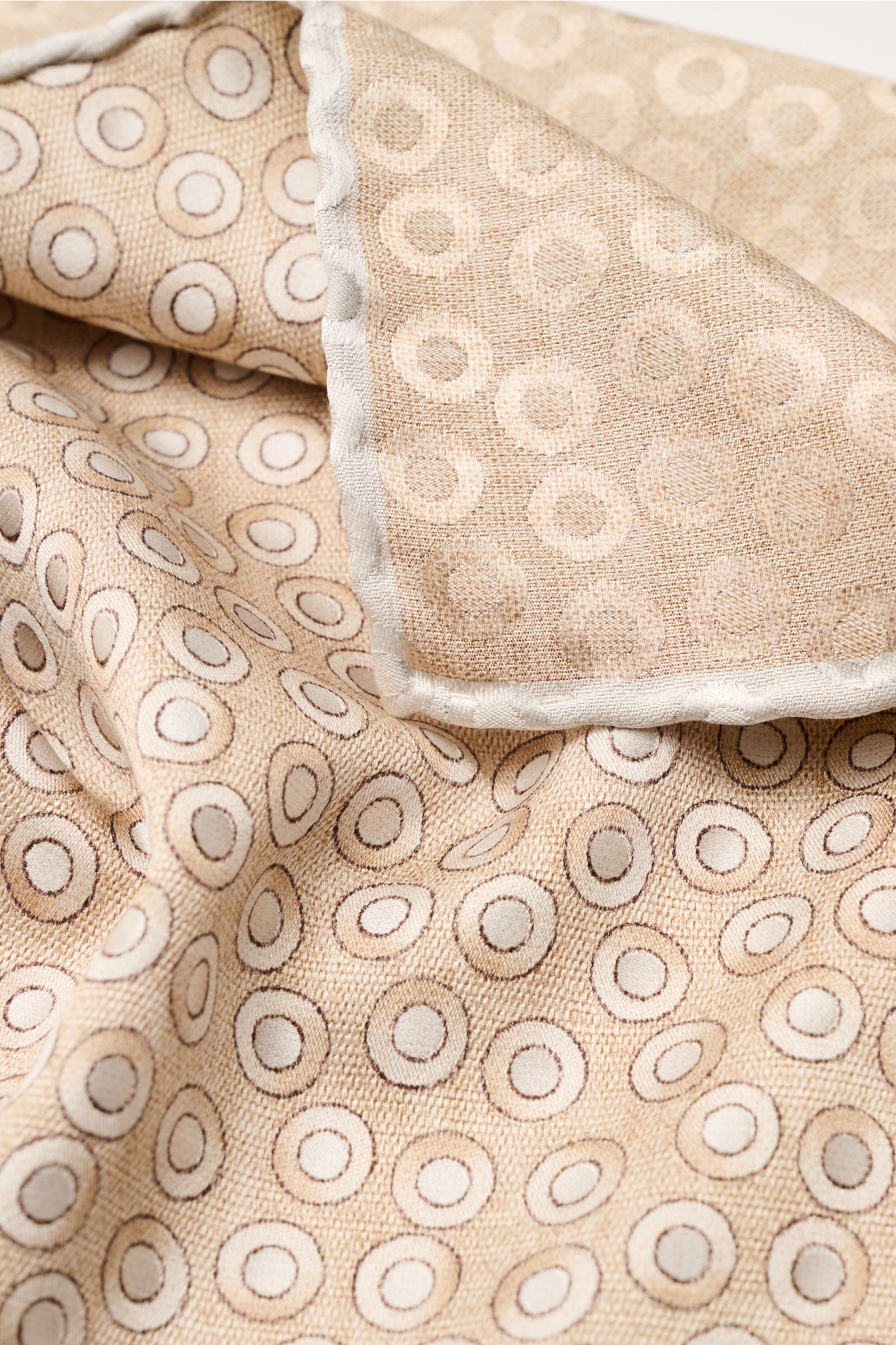 Close-up from above of the Brunello Cucinelli Seiden-Einstecktuch gold/hellgrau gepunktet, a silk pocket square with a subtle dotted pattern, hand-rolled edges, and smooth texture.

Quiet Luxury heißt der große Trend: Das kann BRUNELLO CUCINELLI besond