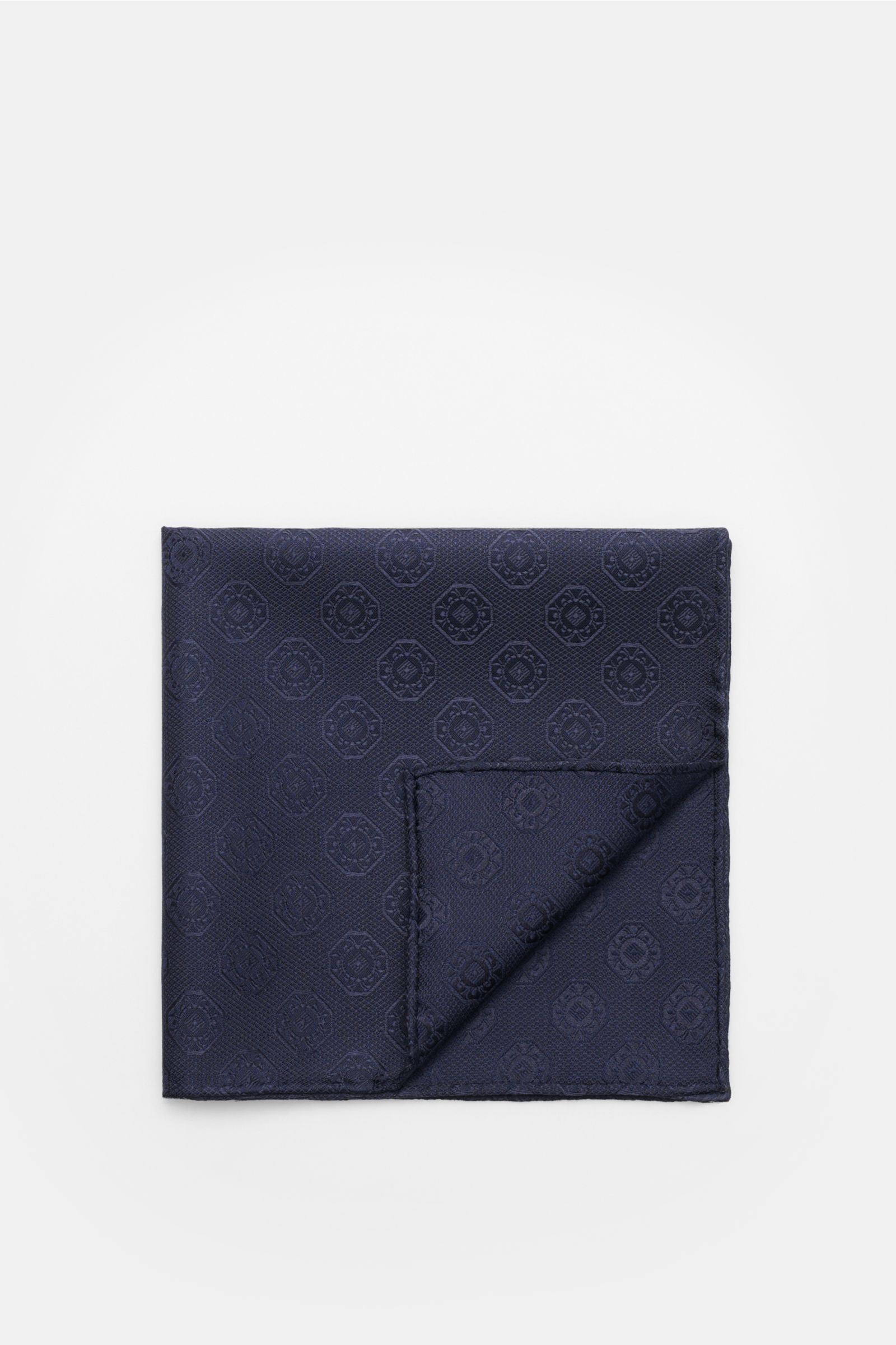 Top-down view of the Brunello Cucinelli Silk pocket square dark navy, patterned, folded to show its medallion weave and rolled edges.

Elegant accent: This silk pocket square by BRUNELLO CUCINELLI has a fine medallion weave pattern that creates a subtl