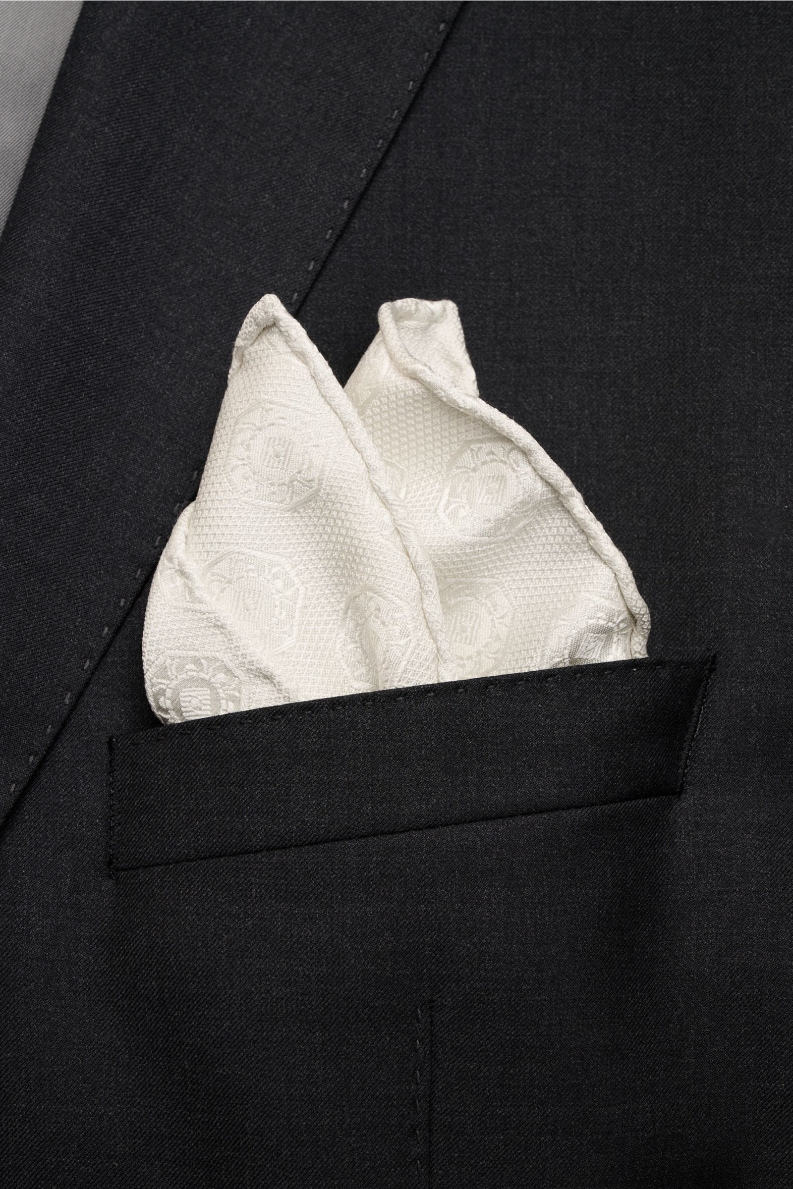Close-up front view of a Brunello Cucinelli Silk pocket square cream patterned, elegantly folded in a black jacket pocket.

Elegant accent: This silk pocket square by BRUNELLO CUCINELLI has a fine medallion weave pattern that creates a subtle highlight