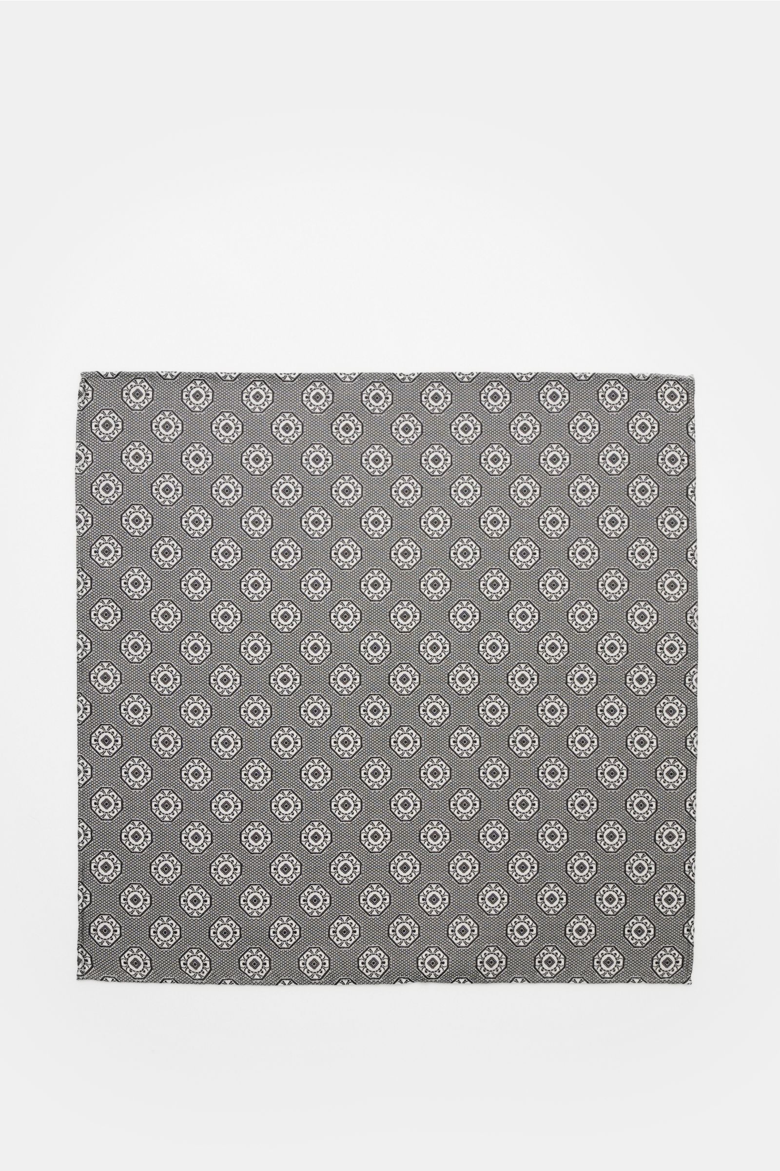 Top-down view of the Brunello Cucinelli Silk pocket square grey/black patterned, featuring a fine medallion weave and rolled edges.

Elegant accent: This silk pocket square by BRUNELLO CUCINELLI has a fine medallion weave pattern that creates a subtle 