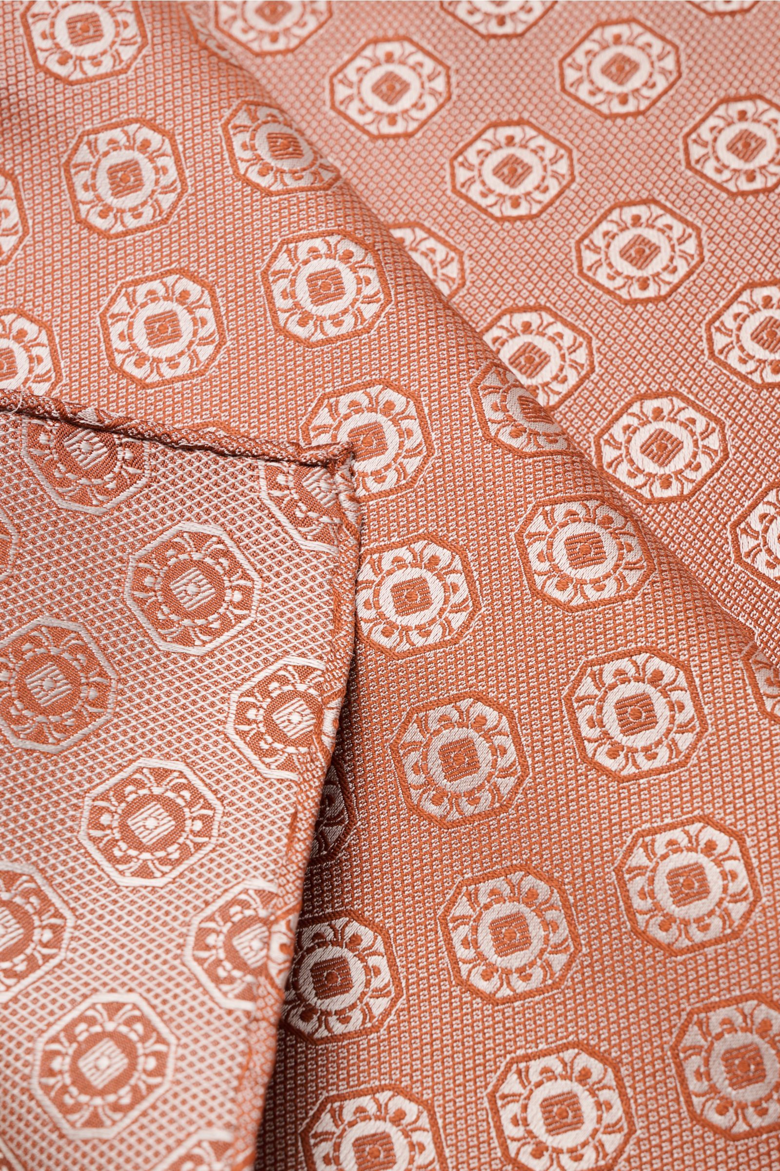 Brunello Cucinelli Silk pocket square rust brown/light grey patterned, close-up top-down view showing medallion weave and rolled edges.

Elegant accent: This silk pocket square by BRUNELLO CUCINELLI has a fine medallion weave pattern that creates a sub
