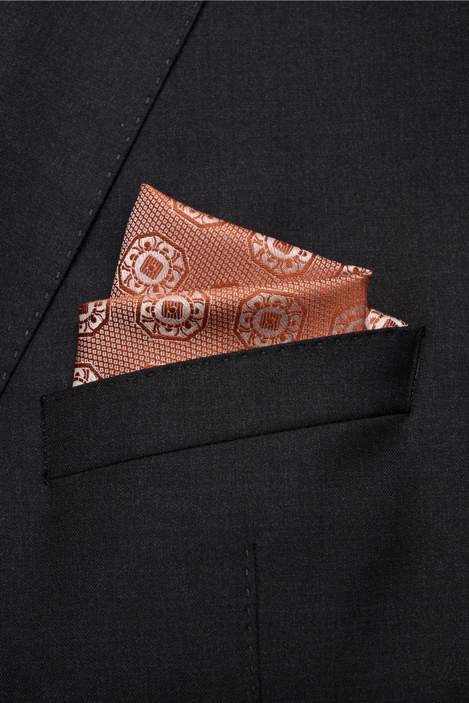 Close-up front view of a Brunello Cucinelli Silk pocket square rust brown/light grey patterned elegantly folded in a black jacket pocket.

Elegant accent: This silk pocket square by BRUNELLO CUCINELLI has a fine medallion weave pattern that creates a s