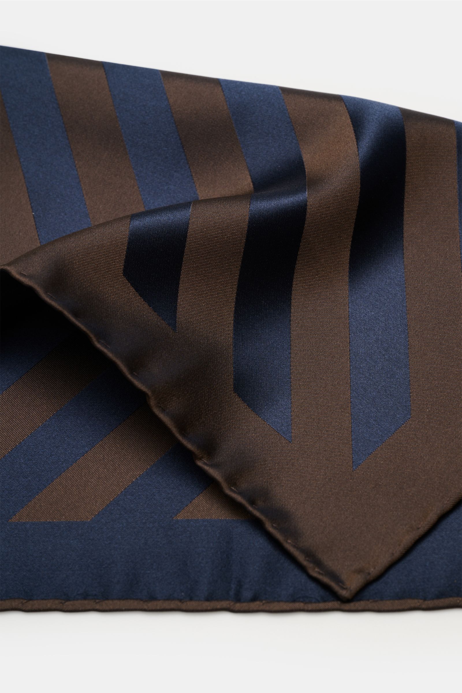 Brunello Cucinelli Seiden-Einstecktuch dunkelbraun/dark navy gestreift, aus reiner Seide mit edlem Streifenmuster, rollierten Kanten, glattem Griff, fotografiert aus Nahaufnahme seitlich.