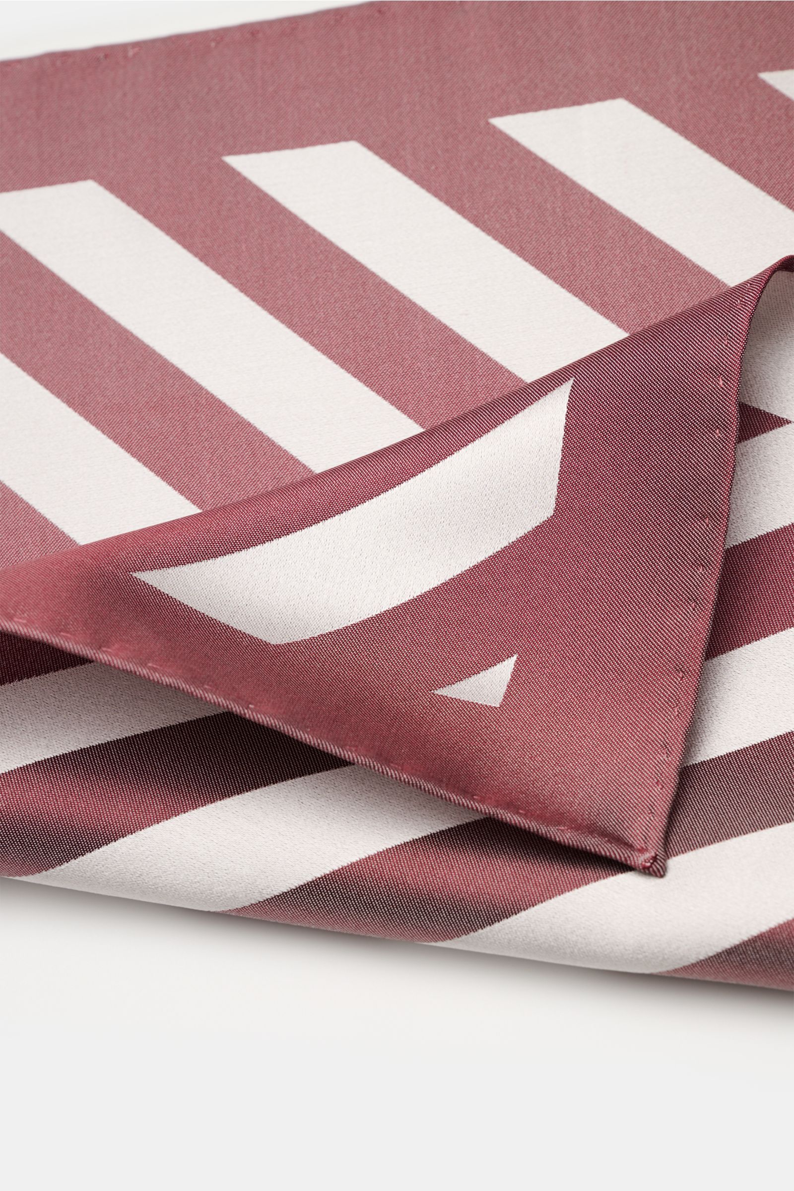 Brunello Cucinelli Seiden-Einstecktuch bordeaux/silbergrau gestreift, aus reiner Seide mit edlem Streifenmuster, glatt und rollierte Kanten, nah fotografiert von oben schräg.