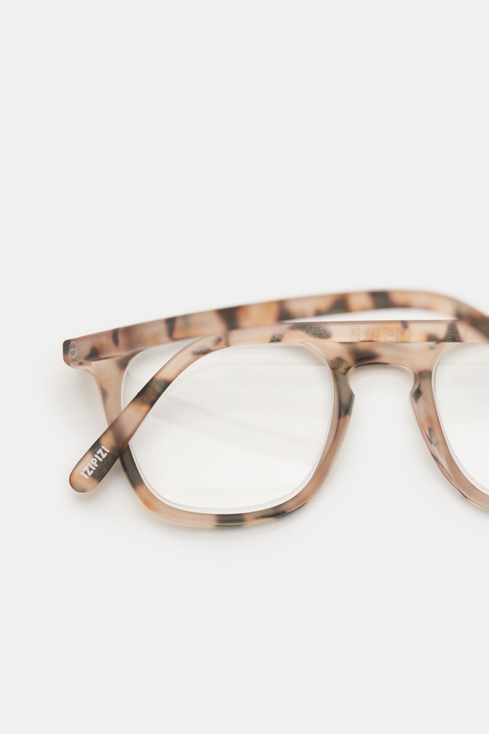 Close-up, top-front perspective of Izipizi Reading glasses '#E' beige/black with slightly square shape and soft-touch frame, plastic lenses with prescription.

A modern accessory with a useful function: This '#E' reading glasses model by the French lab