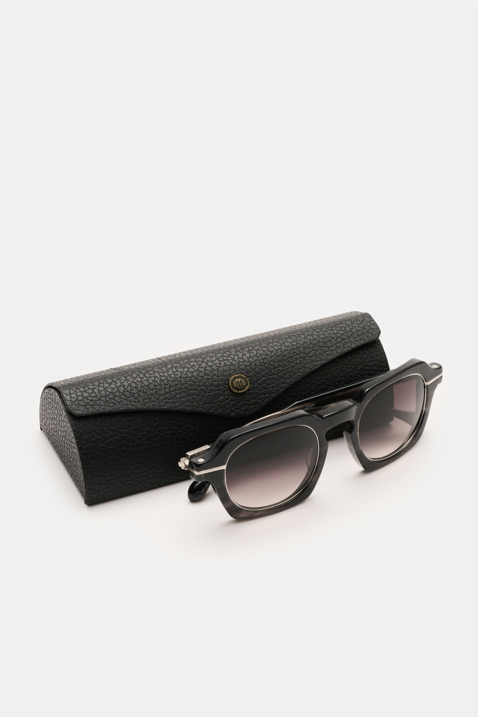 Matsuda Sonnenbrille 'M2055' in anthrazit/grau, eckig, Notched Bridge, Acetat-Rahmen, Metall-Details, vor Etui, seitlich fotografiert.