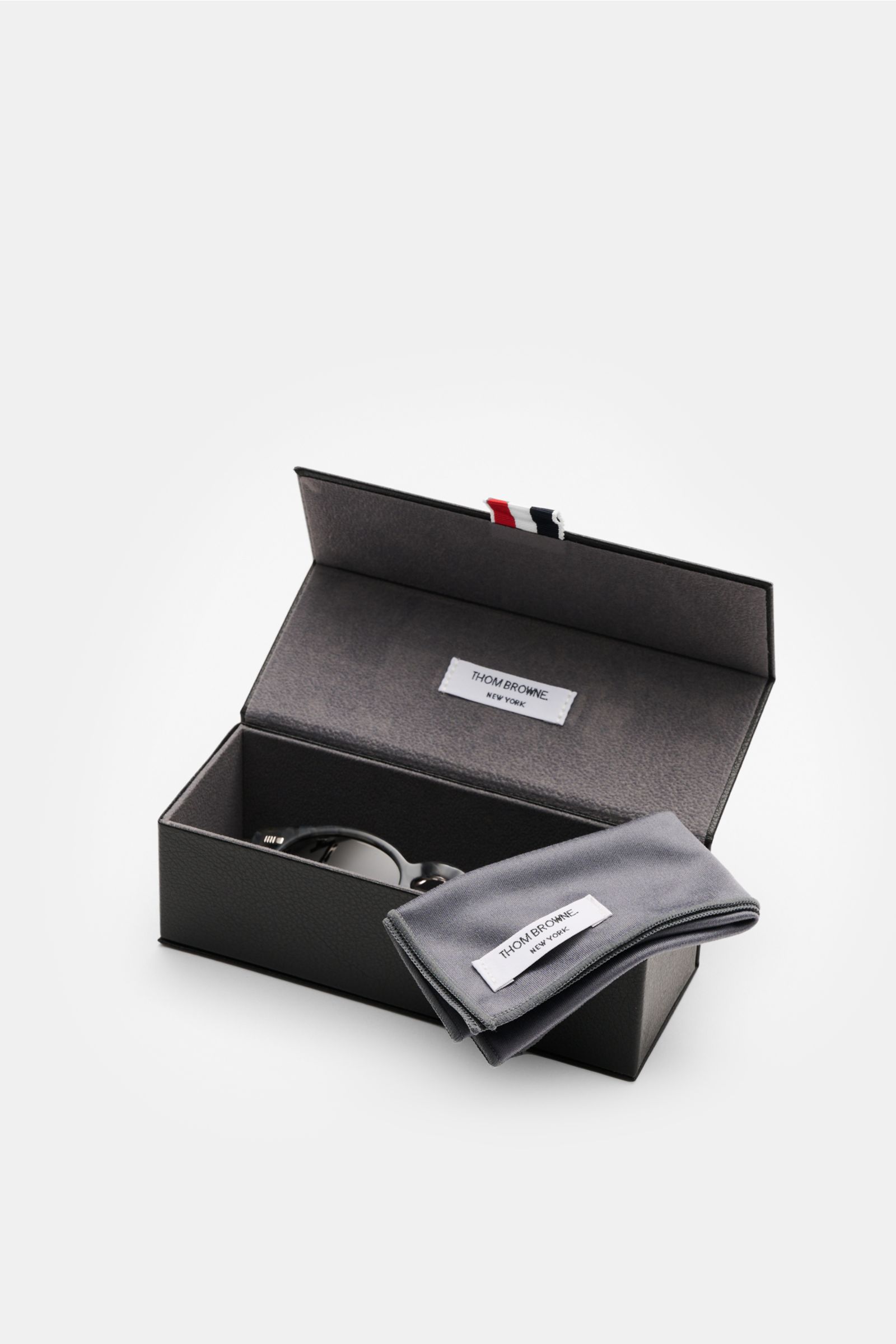 Thom Browne Sonnenbrille grau mit klassischer Notched-Bridge-Form, Schildpatt-Acetat-Rahmen, getönten Gläsern, 100% UV-Schutz, Hartschalenetui, von oben fotografiert.