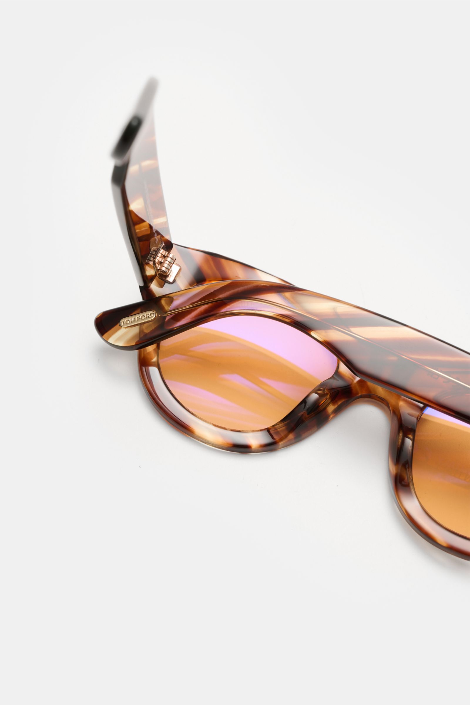 Close-up side view of Tom Ford Sonnenbrille 'Lucinda' braun/hellbraun gemustert with rounded silhouette, photochrome lenses, and acetate frame.

Description:  
Stilvoller Allrounder: Die moderne Sonnenbrille von TOM FORD wird zum vielseitigen Eyecatche
