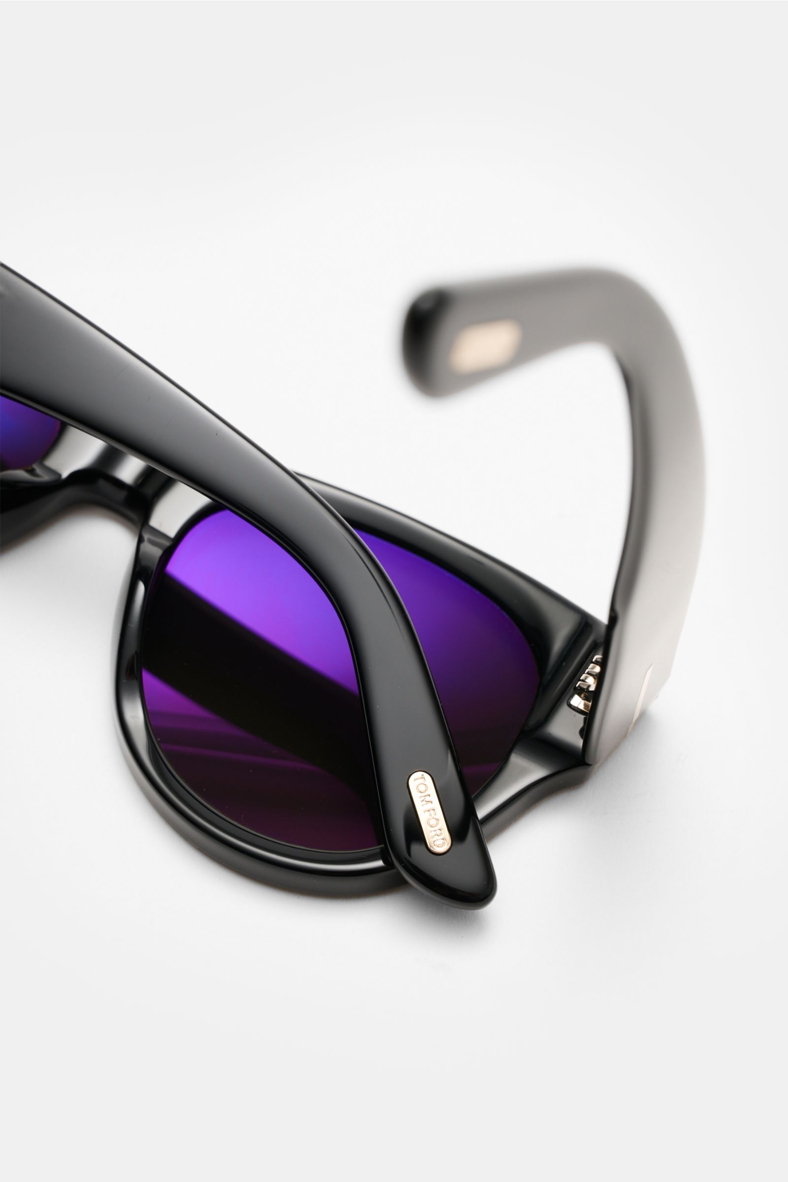 Close-up rear view of Tom Ford Sunglasses 'Burton' black with acetate frame, purple tinted lenses, and logo detail on temple tip. Stylish all-rounder: With their timeless design, these sunglasses by TOM FORD are an ideal summer essential. Slightly rounded