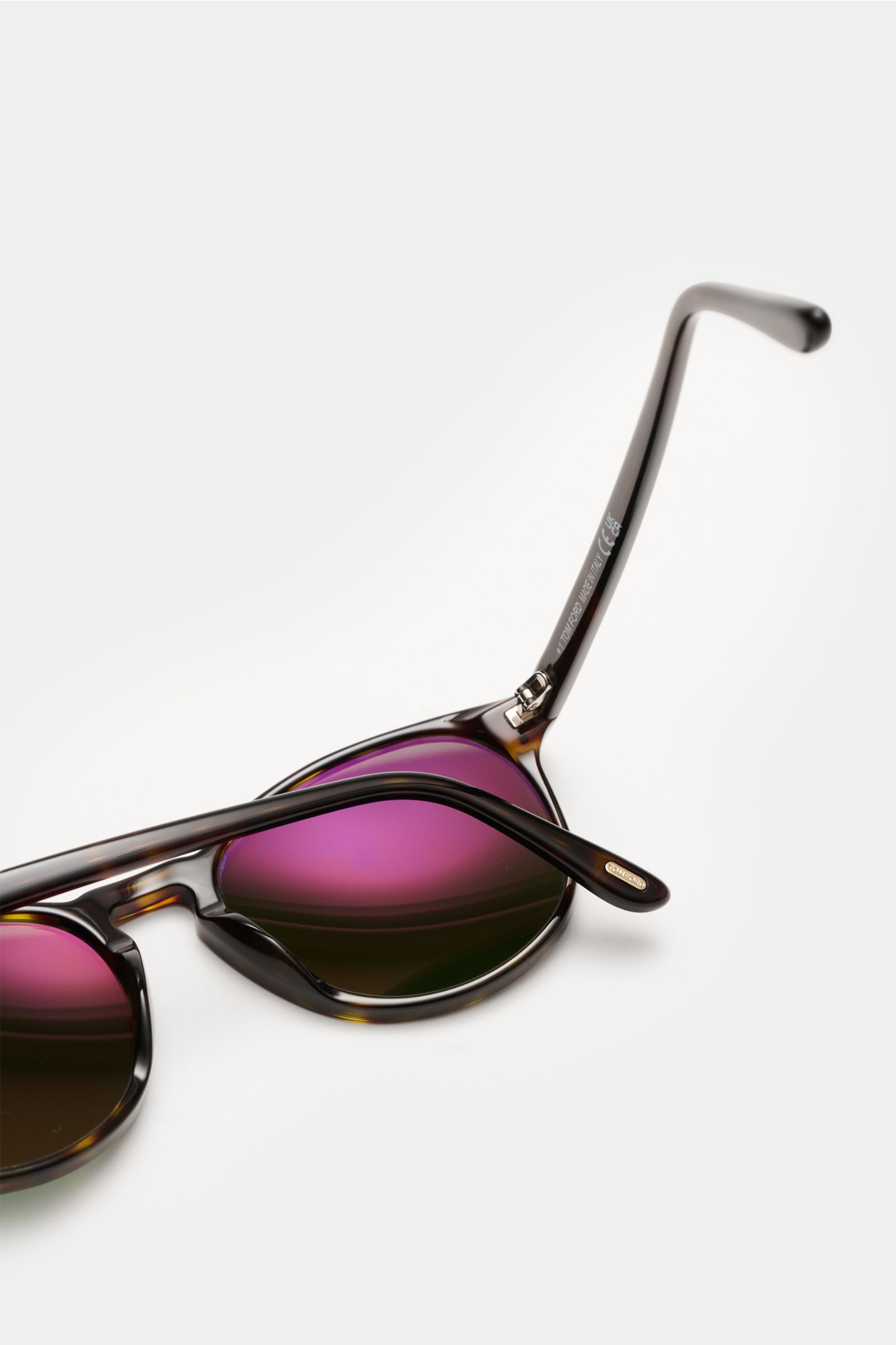 Tom Ford Sonnenbrille 'Lewis' dunkelbraun meliert mit leicht gerundeter Silhouette, melierter Optik, violett getönten Kunststoffgläsern, Acetat-Rahmen, von schräg oben fotografiert.