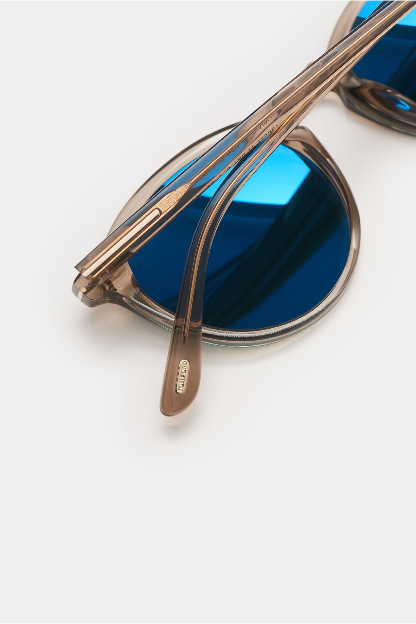 Close-up top view of Tom Ford Sonnenbrille 'Aurelie' graubraun sunglasses showing the transparent gray-brown acetate frame and evenly tinted blue plastic lenses. Features include klassische Notched-Bridge-Form, gleichmäßig getönte Kunststoffgläser, Acetat