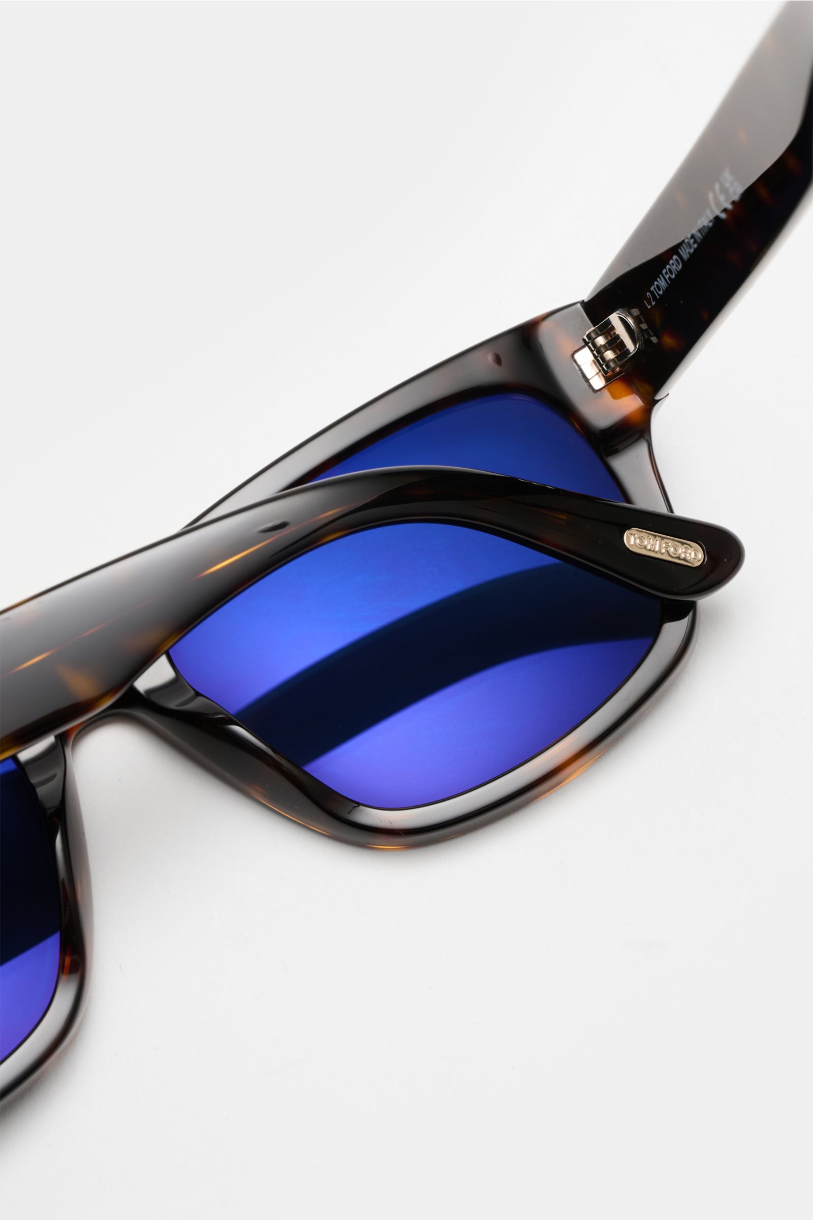 Nahaufnahme der Tom Ford Sonnenbrille 'Smith' dunkelbraun gemustert mit eckigem Acetat-Rahmen und blau getönten Kunststoffgläsern, Filterkategorie 3.