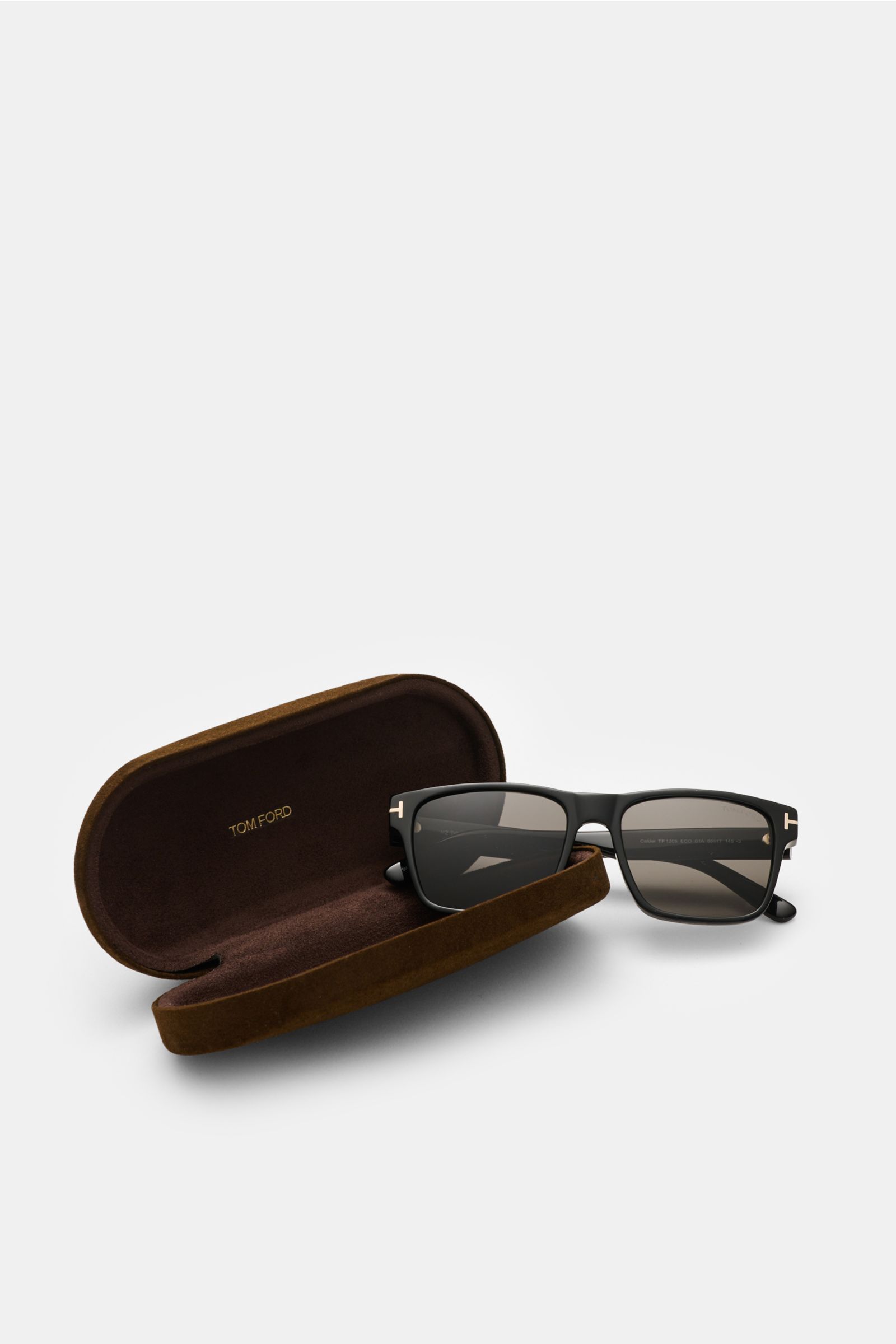 Tom Ford Sonnenbrille 'Calder' schwarz mit eckigem Acetat-Rahmen, polarisierte Gläser, 100% UV-Schutz, seitlich vor offenem Samt-Hartschalenetui, Frontansicht.