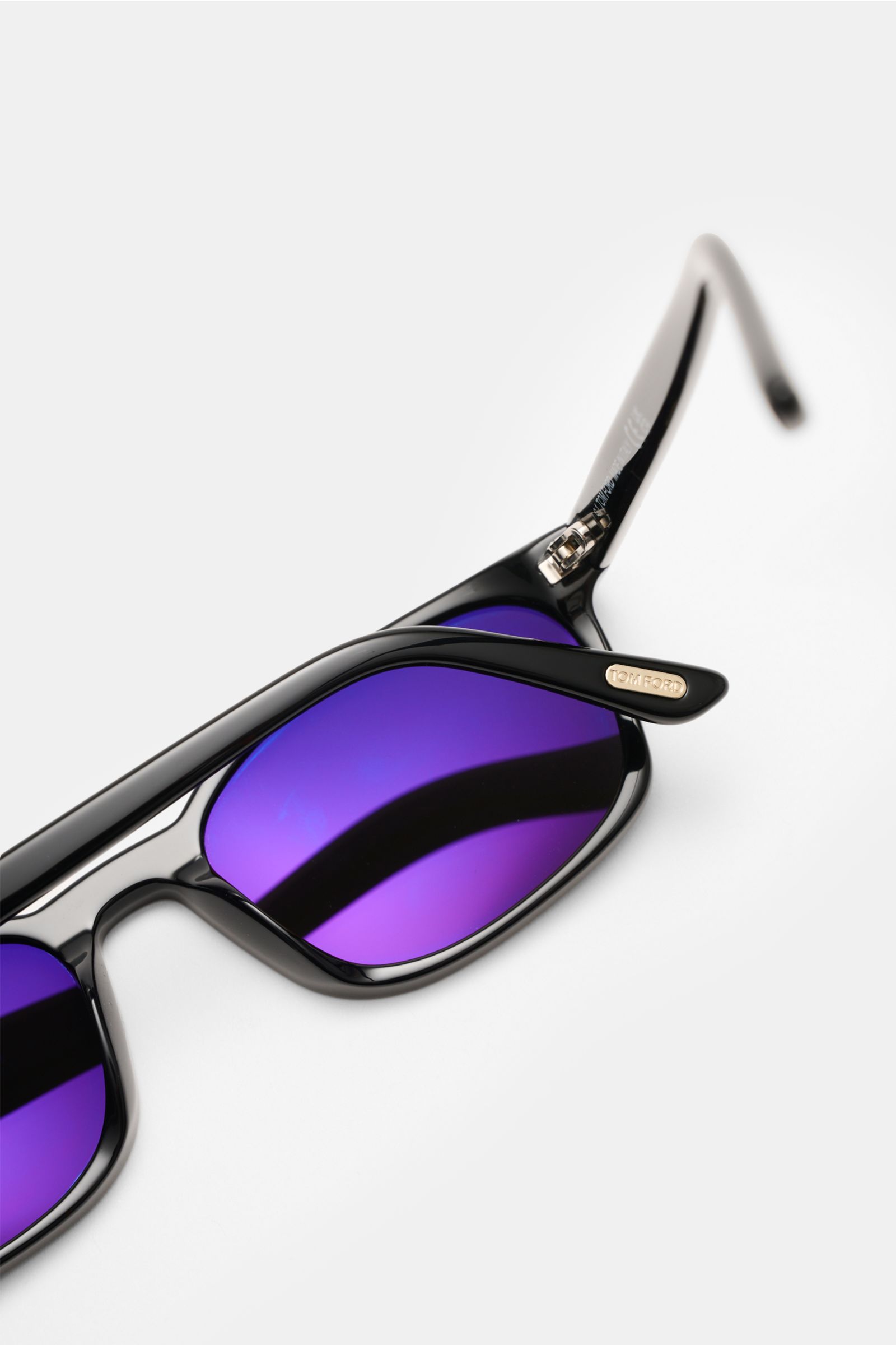 Tom Ford Sonnenbrille 'Miles' schwarz/anthrazit shown from a close-up side angle, featuring slim rectangular acetate frame and purple tinted lenses. Mit der zeitlosen Sonnenbrille 'Miles' von TOM FORD behalten Sie stets den Durchblick. Gleichmäßig getönte