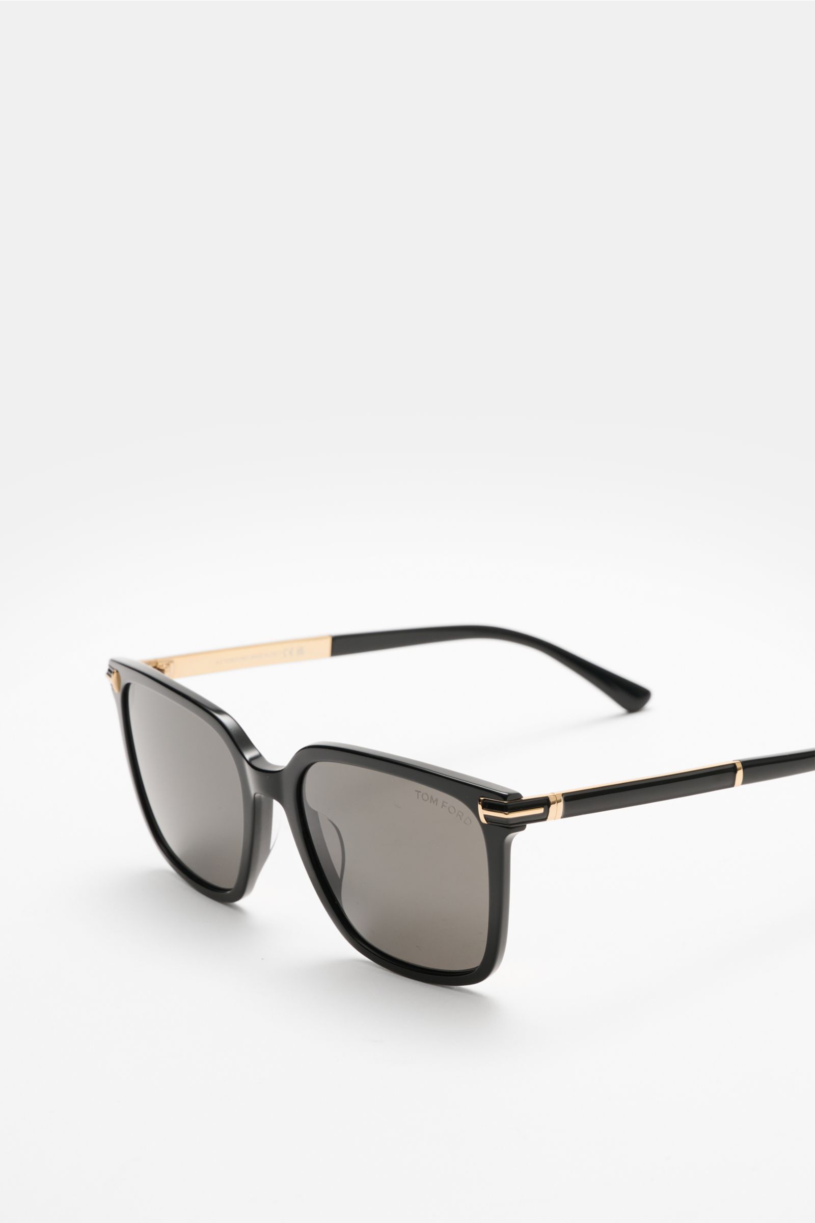 Front-side angled view of Tom Ford Sunglasses 'Jochem' black with slightly square acetate frame, evenly tinted plastic lenses, and gold accents.

Stylish all-rounder: With their timeless design, these sunglasses by TOM FORD are an ideal summer essentia