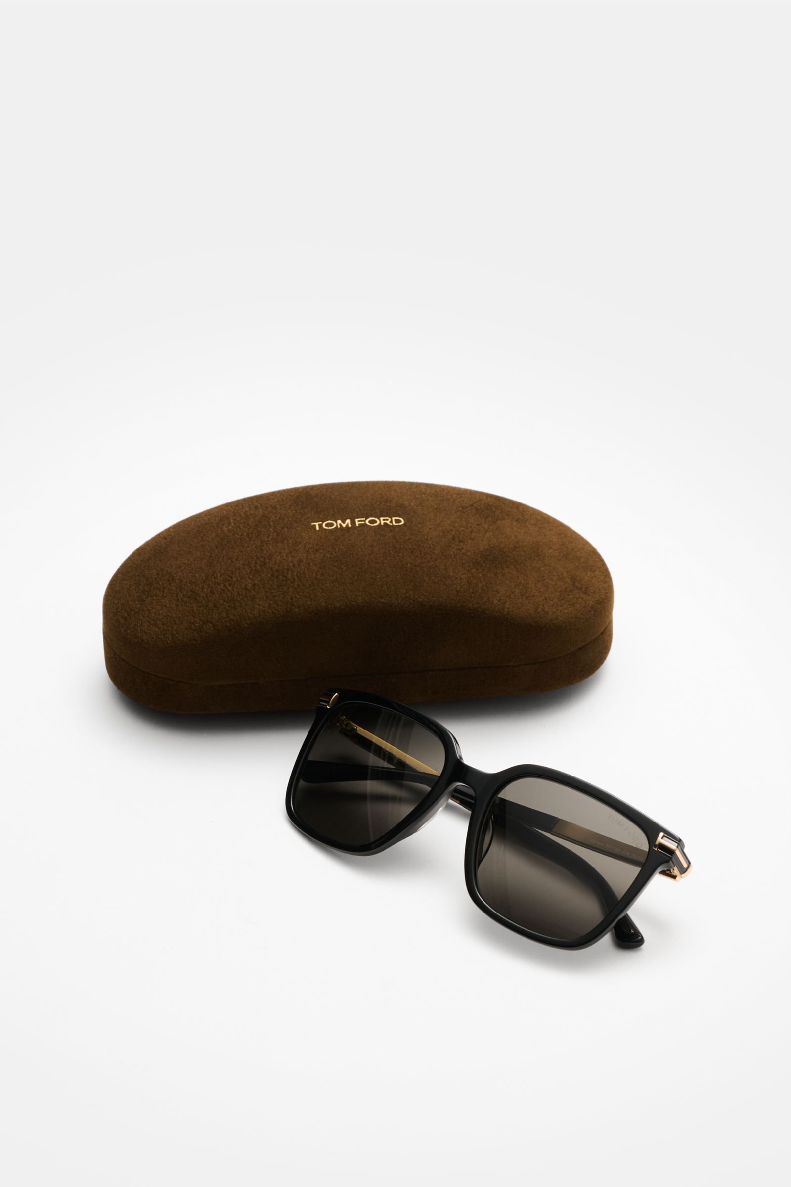 Front angled view of Tom Ford Sunglasses 'Jochem' black with slightly square acetate frame, evenly tinted plastic lenses, and brown velvet hard case. Stylish all-rounder: With their timeless design, these sunglasses by TOM FORD are an ideal summer essenti