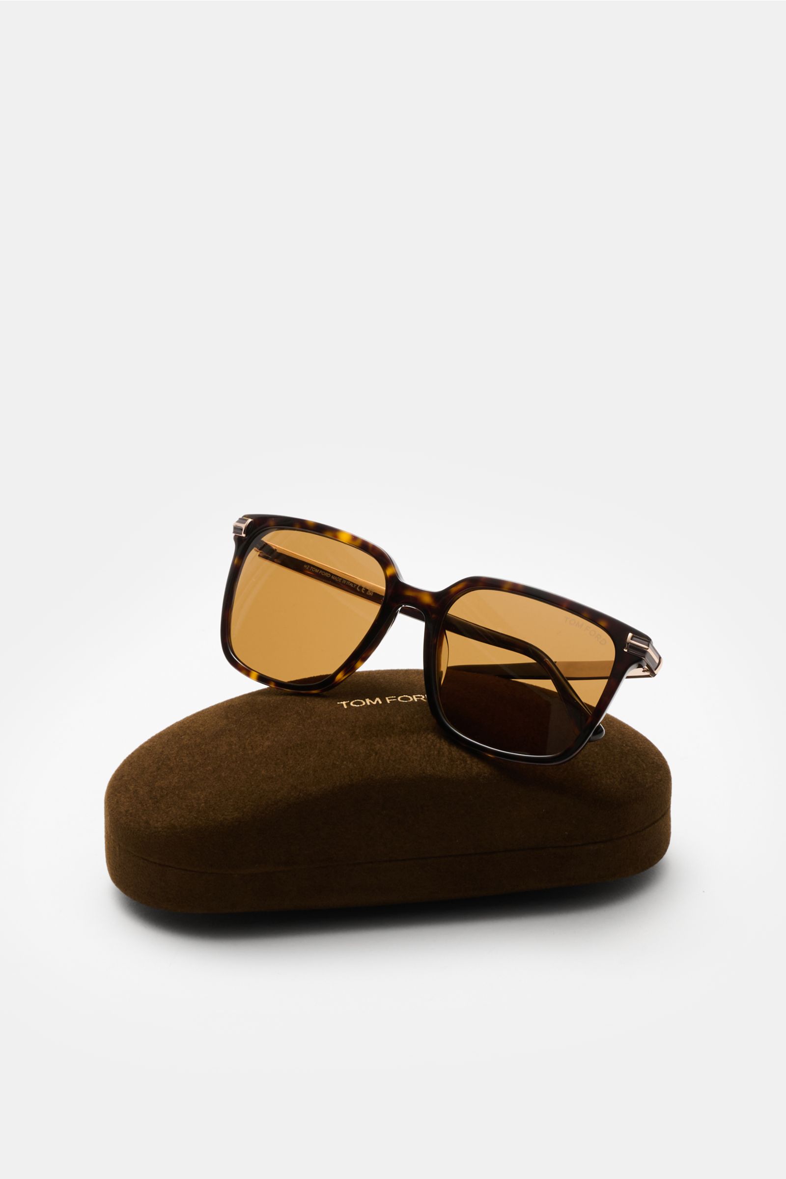 Tom Ford Sunglasses 'Jochem' dark brown mottled with slightly square shape, evenly tinted plastic lenses, acetate frame, shown from a front side angle resting on a brown velvet hard case. Stylish all-rounder: With their timeless design, these sunglasses b