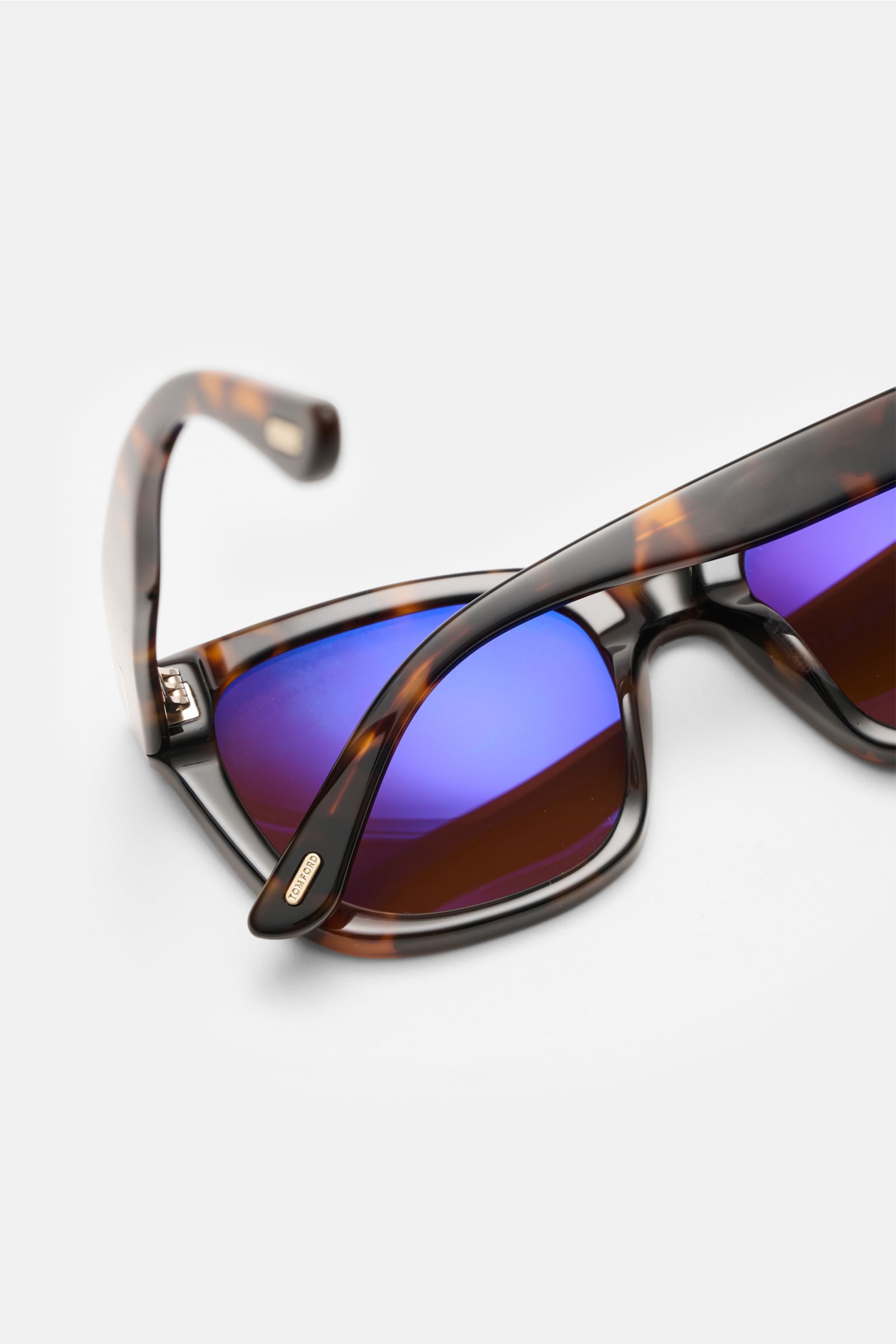 Close-up view of Tom Ford Sunglasses 'Haylay' brown/dark brown patterned with wayfarer acetate frame and blue tinted plastic lenses.

Description: 
TOM FORD guarantees a smart look with the sunglasses 'Haylay' in a timeless tortoiseshell finish – the t