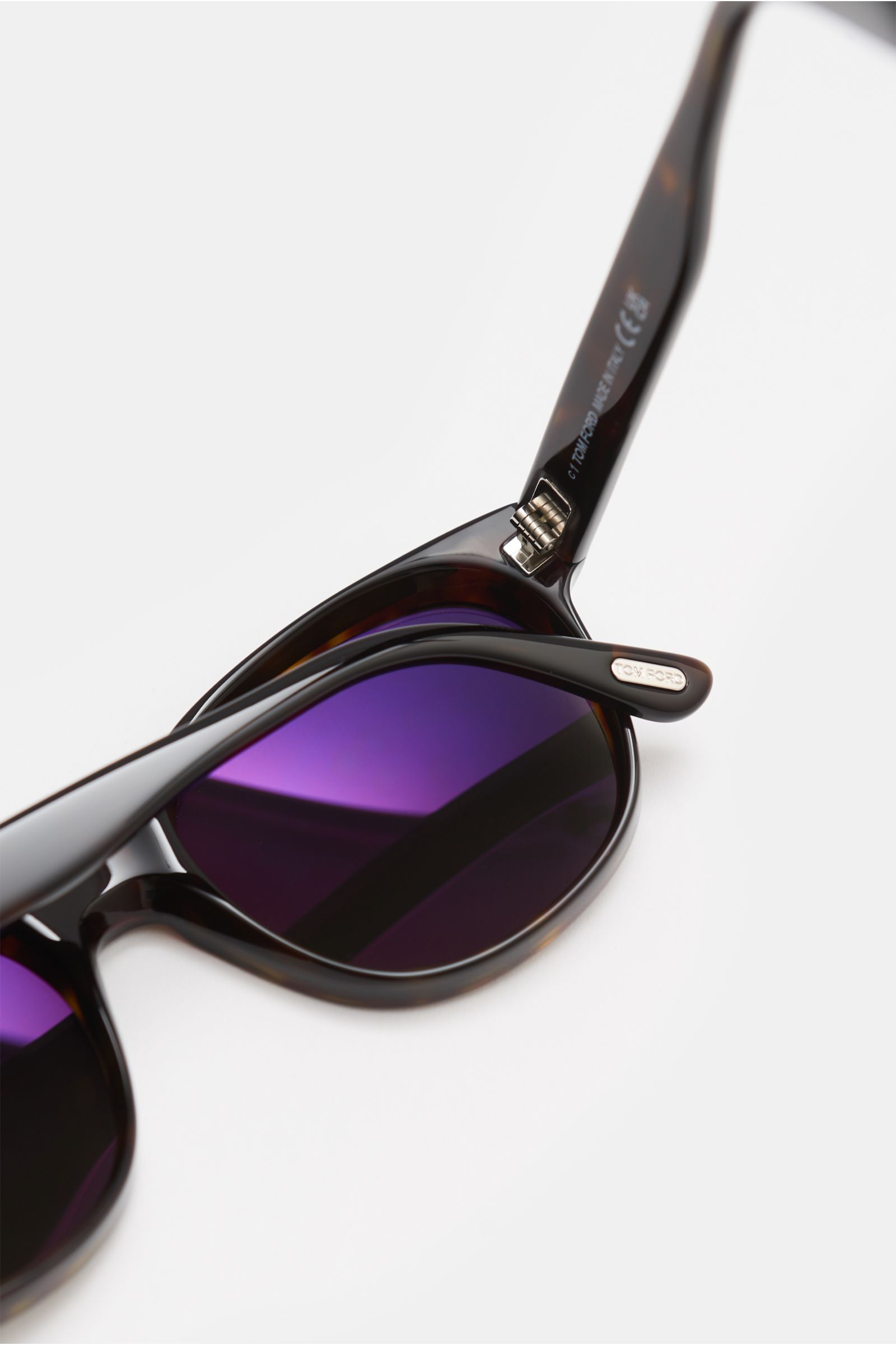 Tom Ford Sonnenbrille 'Mert' dunkelbraun meliert, mit leicht gerundeter Silhouette, meliertem Acetat-Rahmen, lila Kunststoffgläsern, seitliche Nahaufnahme.