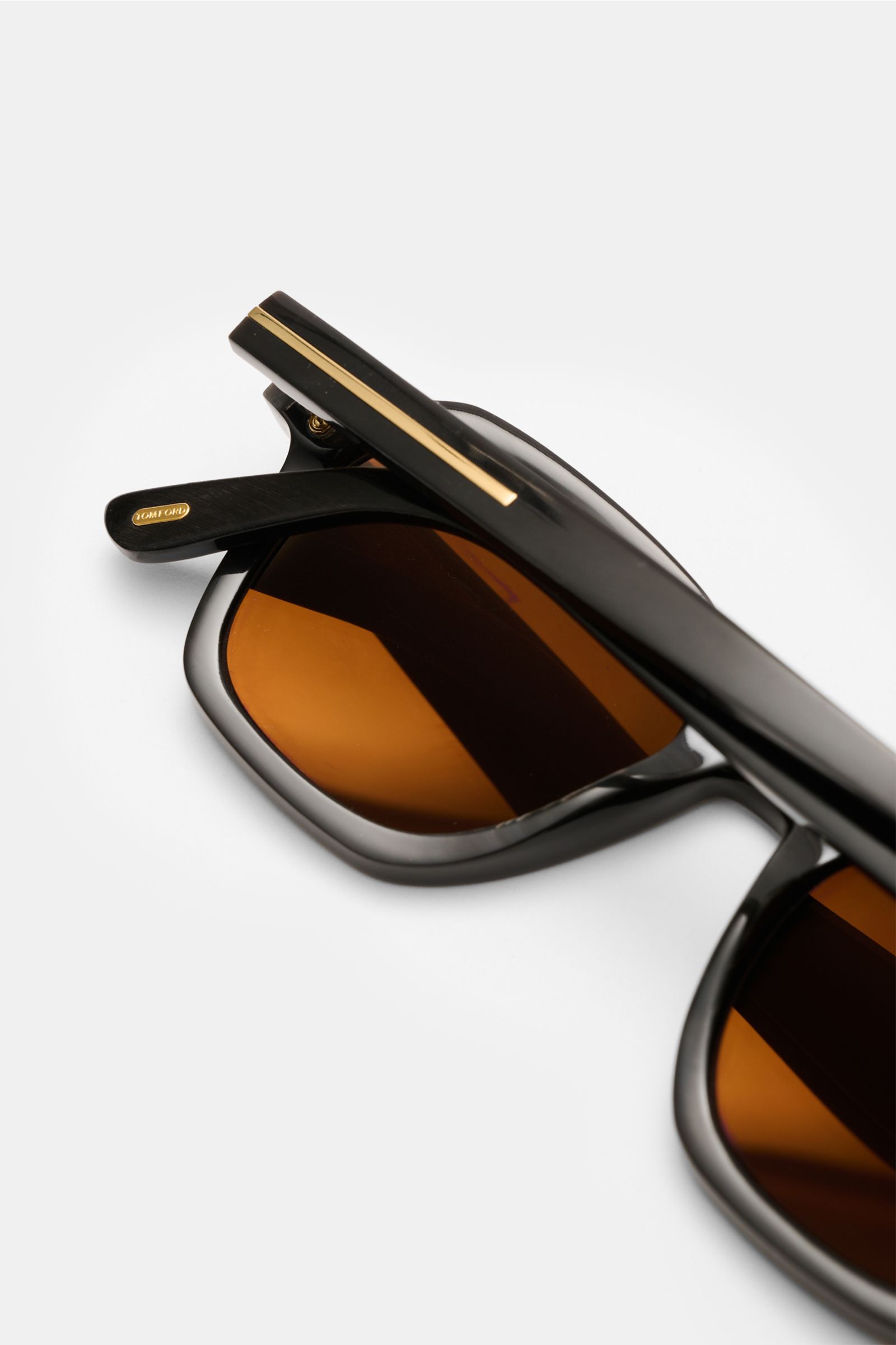 Tom Ford Horn-Sonnenbrille 'Private Collection' dunkelbraun gemustert, leicht eckig, Büffelhornrahmen mit Maserung, goldfarbene Details, braune Gläser, Nahaufnahme seitlich.