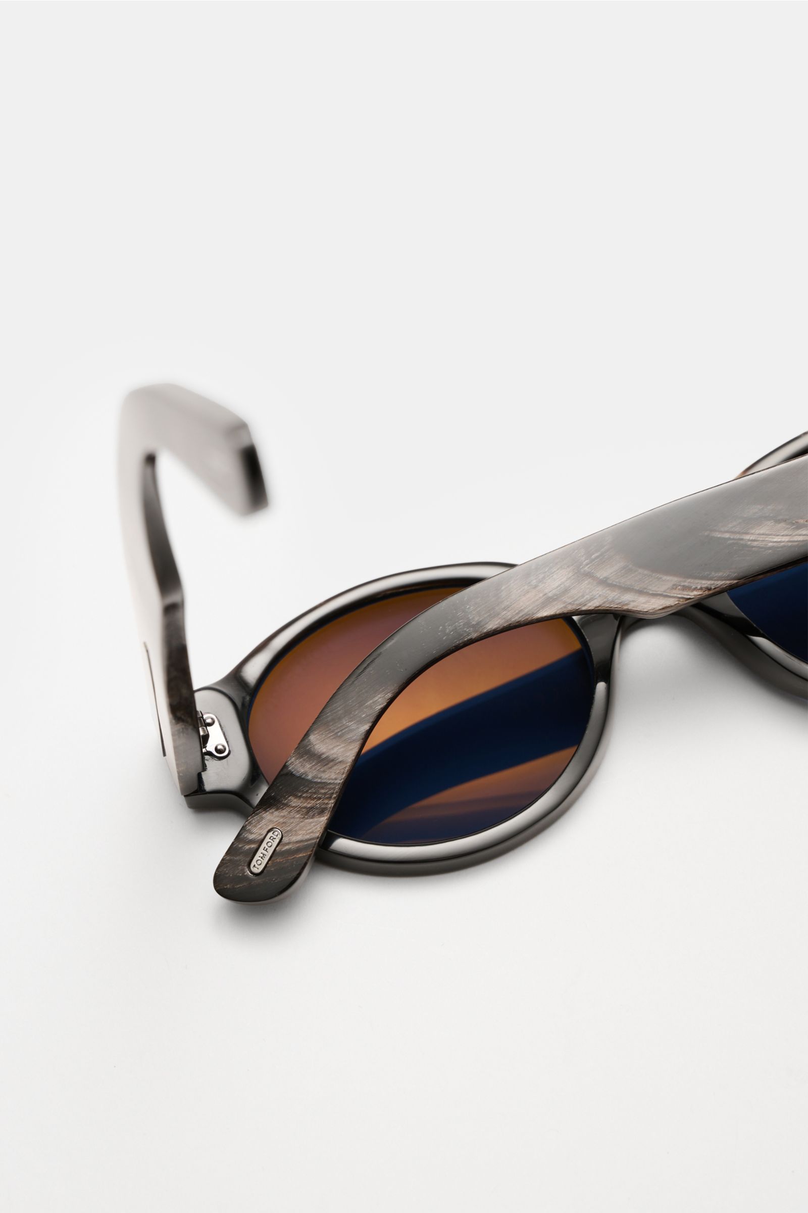 Close-up side view of Tom Ford Horn sunglasses 'Private Collection' black/grey/white patterned with round brown lenses and signature ‘T’ detail.

Description: The luxurious 'Private Collection' by TOM FORD only features exclusive designs worn by the de