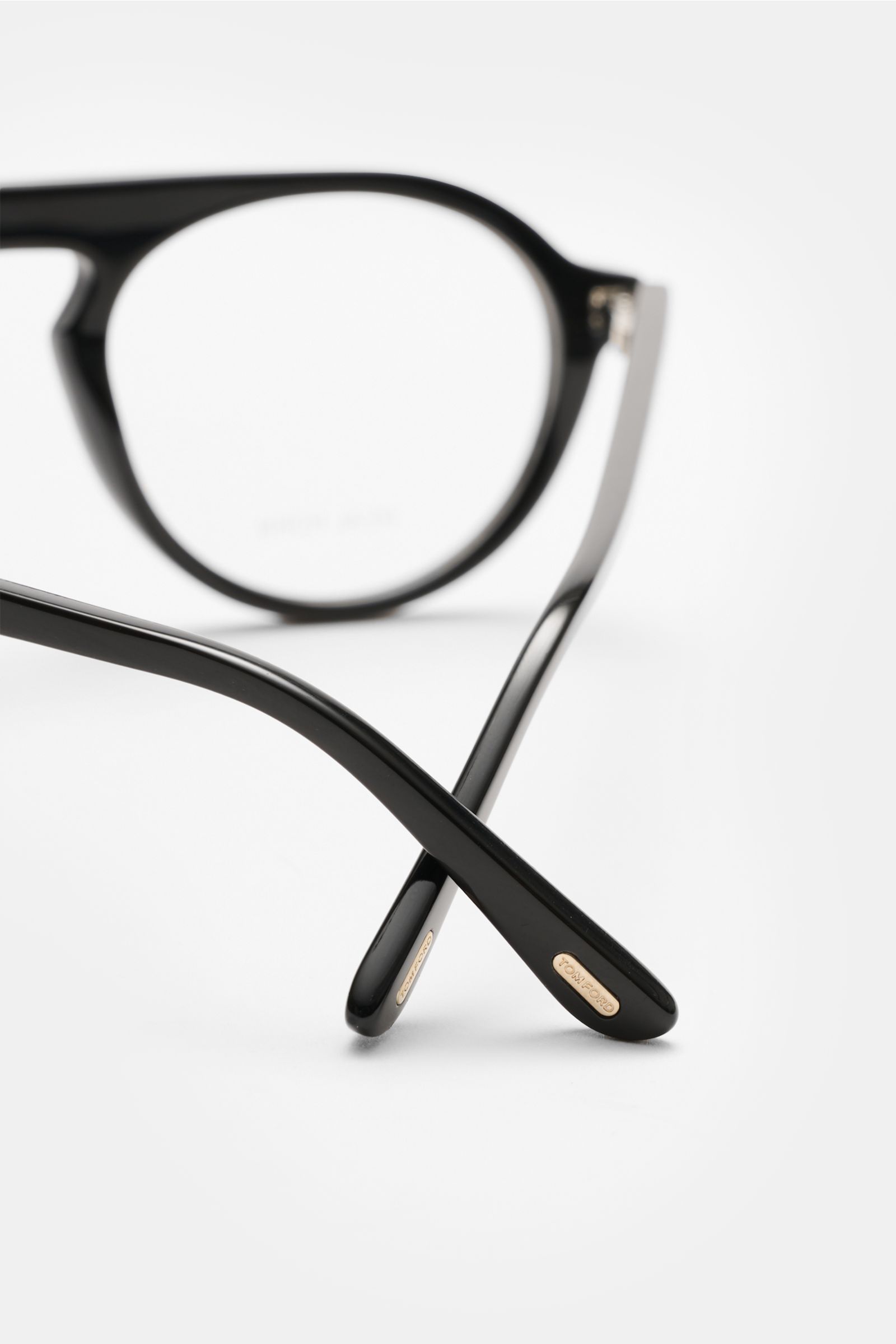 Close-up rear view of Tom Ford Horn Brille 'Private Collection' schwarz/grau/weiß gemustert with round genuine buffalo horn frame, blue light filter lenses, T-shaped details, photographed from the back crossing the black temples. Stilvoller Eyecatcher: Di