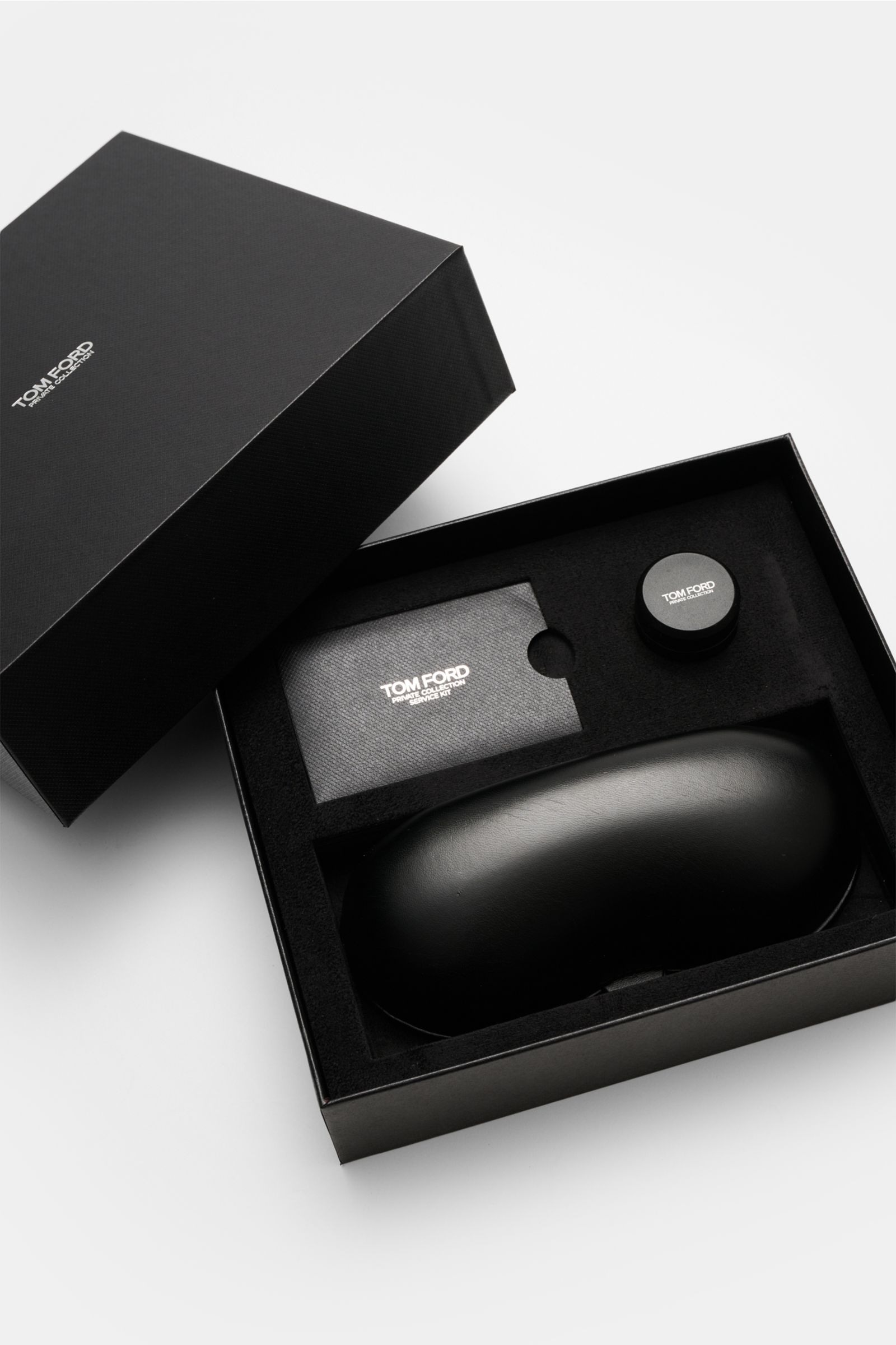 Tom Ford Horn Brille 'Private Collection' schwarz/grau/weiß gemustert packaging set shown from above with leather case, polishing kit, and cleaning cloth included. Stilvoller Eyecatcher: Die exklusive Horn Brille aus der 'Private Collection' von TOM FORD 