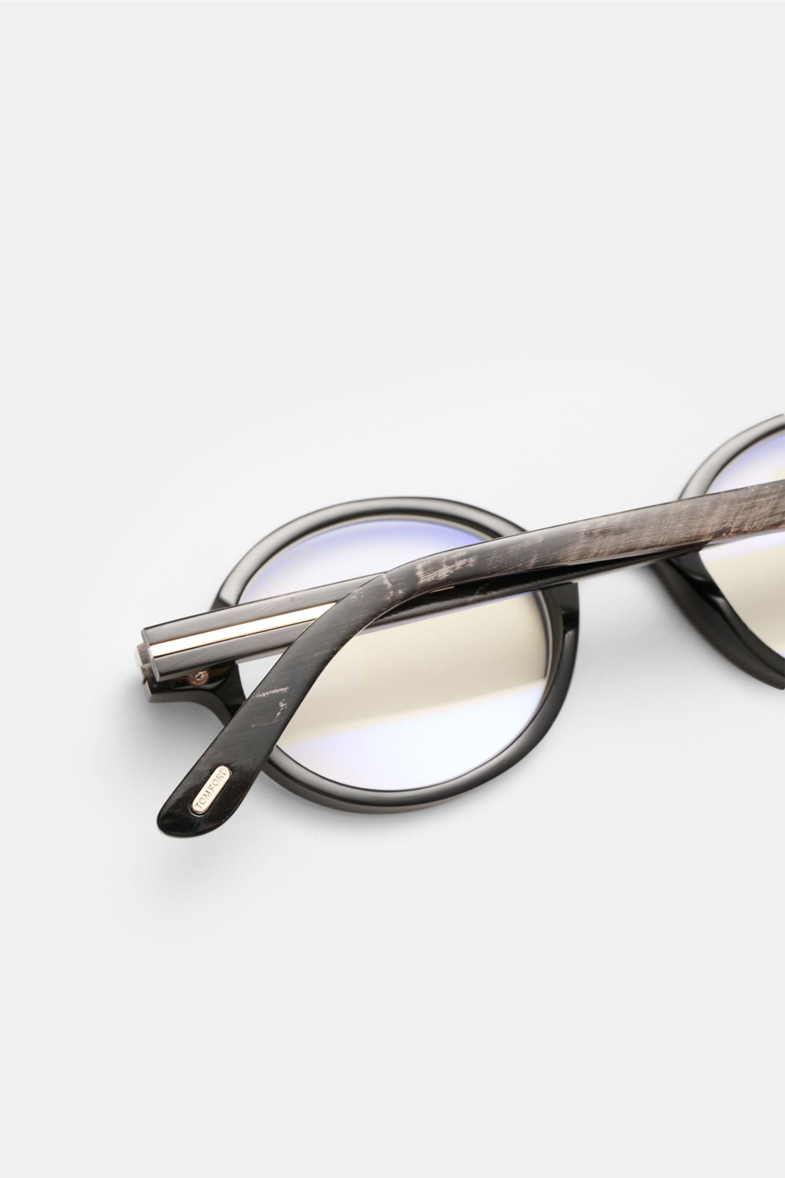Tom Ford Horn Brille 'Private Collection' schwarz/grau gemustert, runde Form, Büffelhorn, Blaulichtfilter, T-Form Details, seitliche Nahaufnahme.