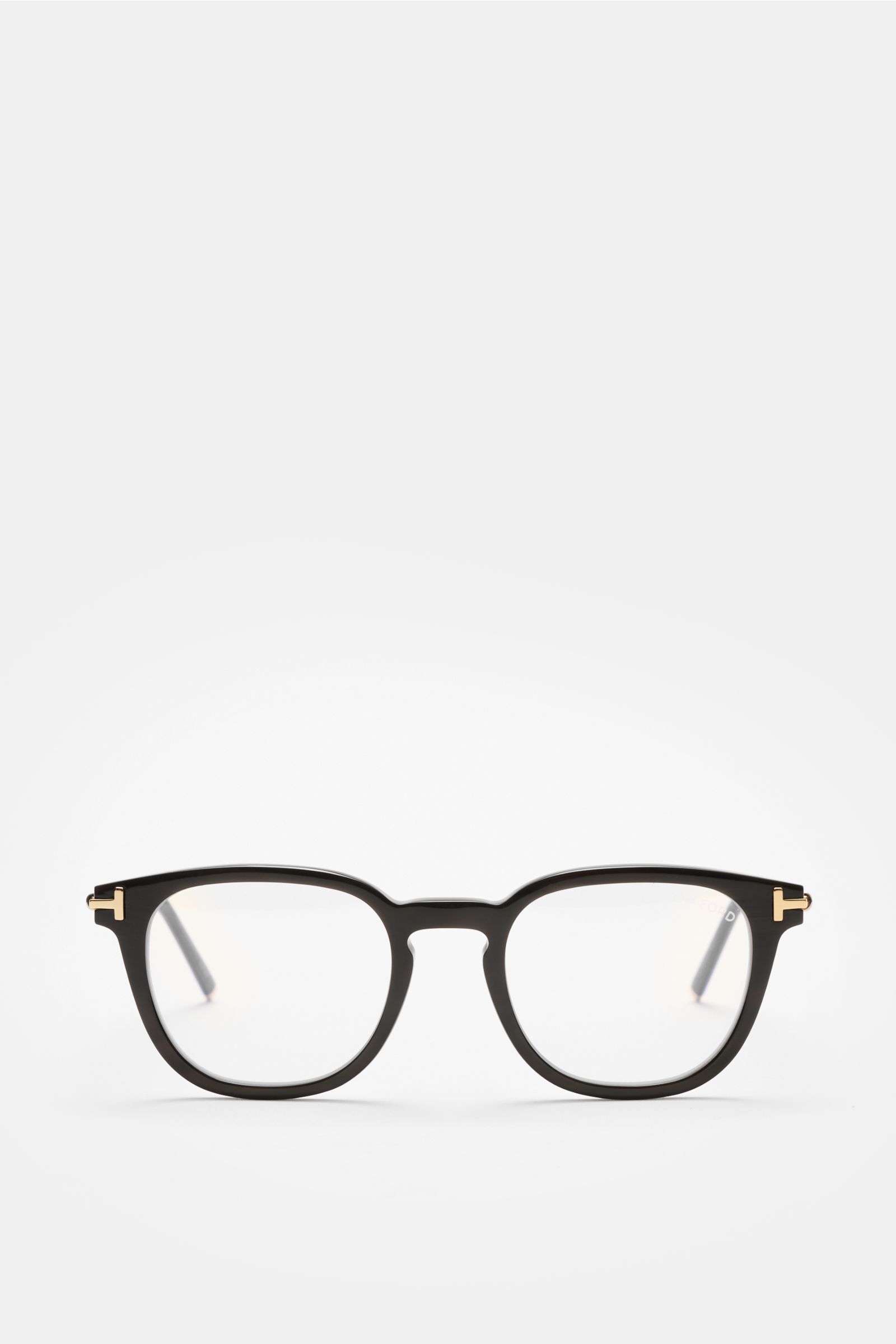 Front view of Tom Ford Horn Brille 'Private Collection' schwarz, a stylish black buffalo horn frame with rounded retro design, T-shaped gold details, and blue light filter lenses. Includes leather case, horn polish set, and cleaning cloth. Stilvoller Eyec