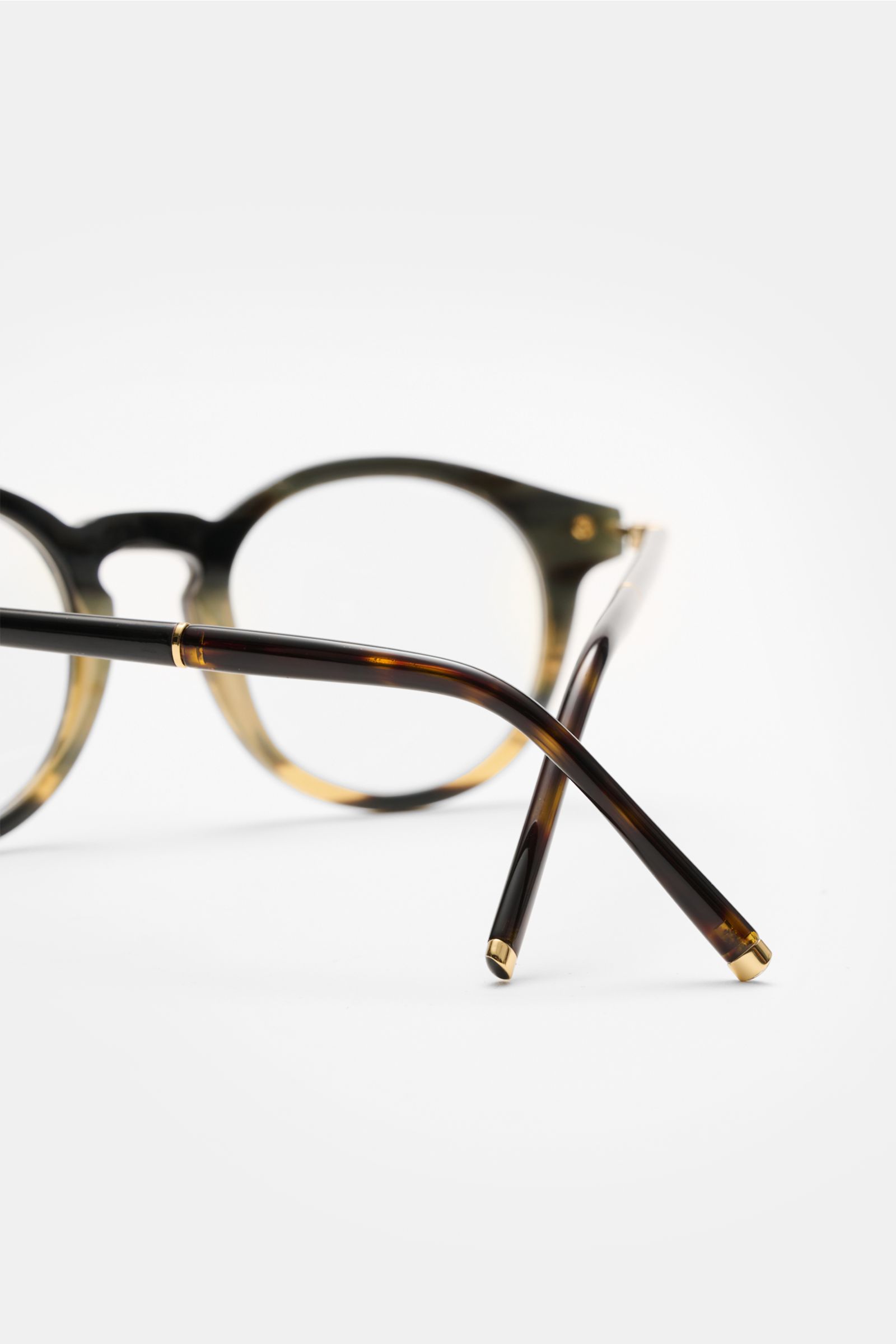 Close-up rear view of Tom Ford Horn Brille 'Private Collection' schwarz/grau gemustert with round frames, buffalo horn material, blue light filter lenses, T-shaped details, and gold accents.

Stilvoller Eyecatcher: Die exklusive Horn Brille aus der 'Pr