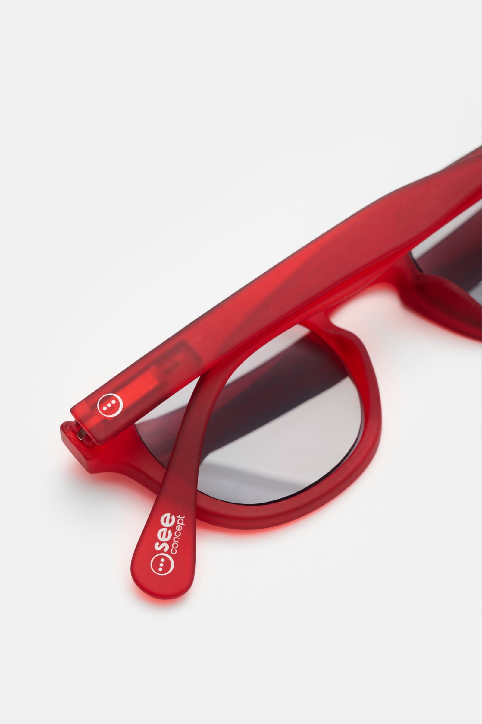 Izipizi Sonnen-Lesebrille '#C Red Crystal' rot, leicht eckige Form, Soft Touch-Rahmen, Kunststoffgläser +1,5, 100% UV, verdunkelt, Filzetui, Nahaufnahme schräg.