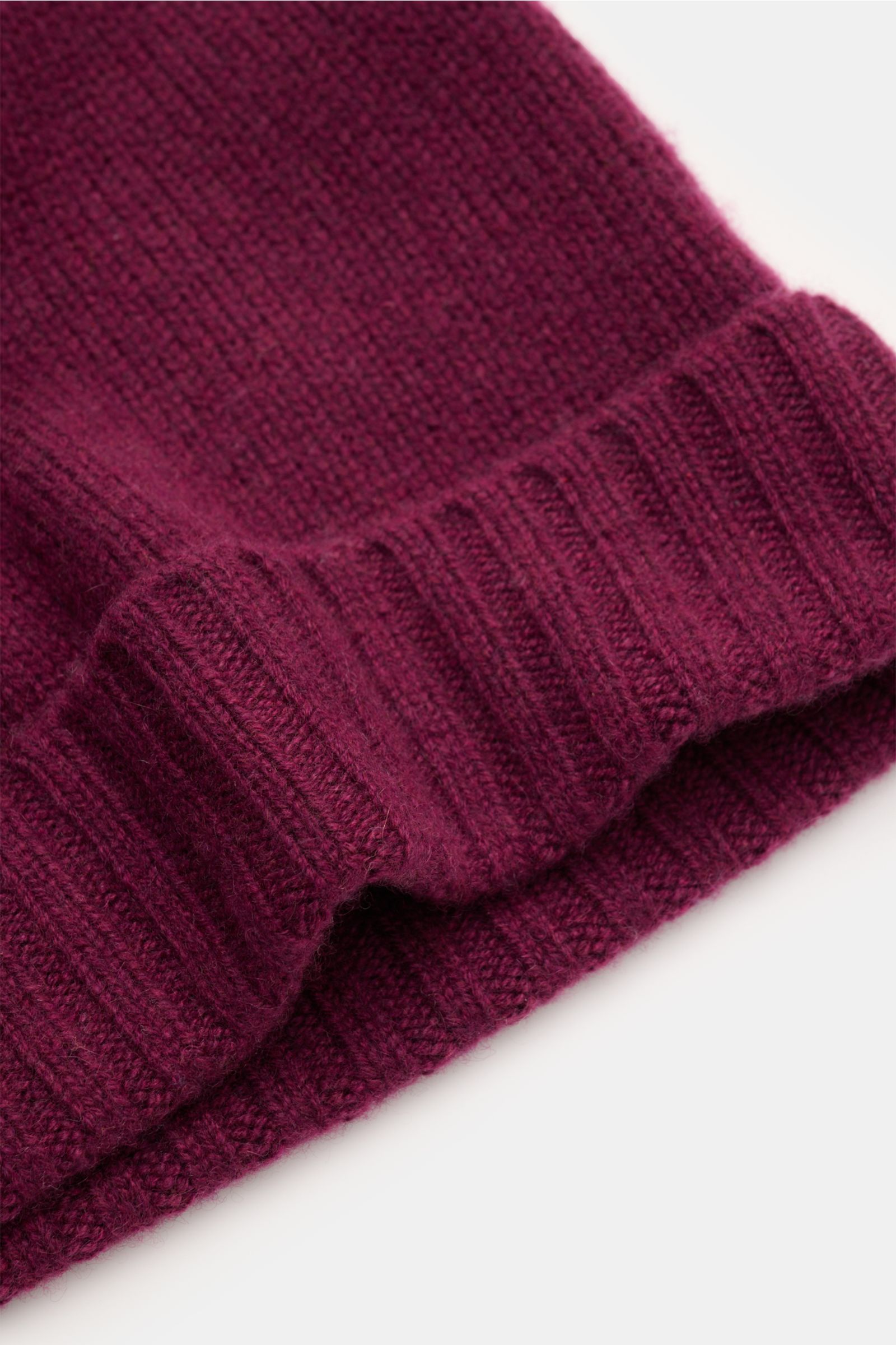 Nahaufnahme der von Braun Cashmere Mütze bordeaux mit schmalem Umschlag, feinem Strickbild und sehr weichem Griff aus reinem Cashmere, leicht seitlich fotografiert.