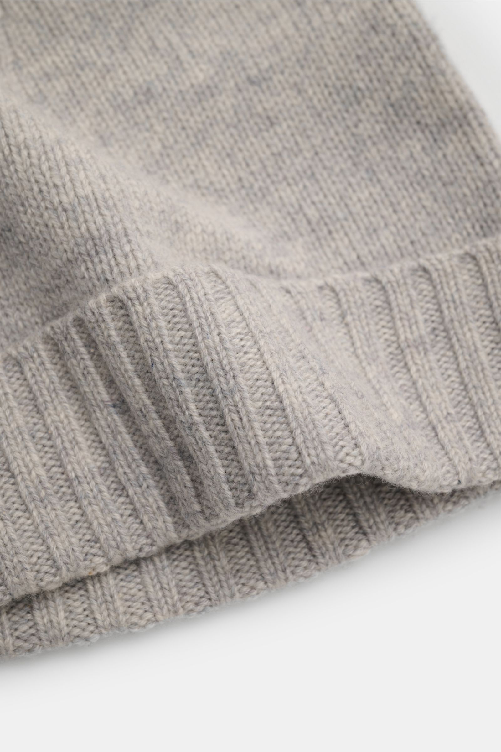 Close-up view from the side of the von Braun Cashmere Mütze hellgrau meliert, a soft light grey cashmere knit hat with a fine stitch pattern and narrow cuff, made of pure cashmere with a very soft feel. Egal, ob zum klassischen Wintermantel oder zur ho