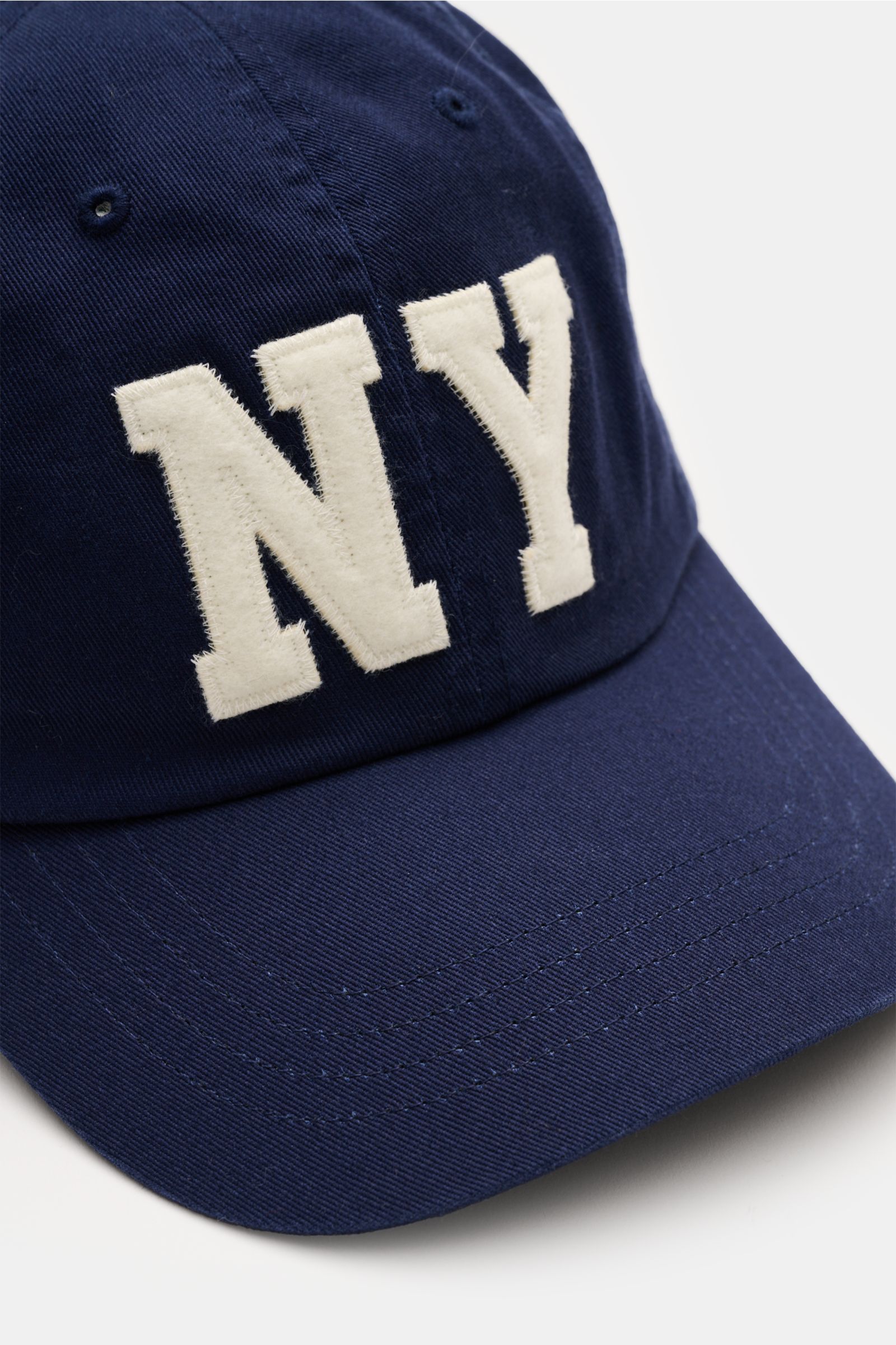 Close-up front-right view of Polo Ralph Lauren Baseball-Cap navy made of pure cotton with classic six-panel design, NY patch on front, and adjustable closure. Lässige Looks: Die Baseball-Cap von POLO RALPH LAUREN überzeugt als vielseitiges Accessoire für 
